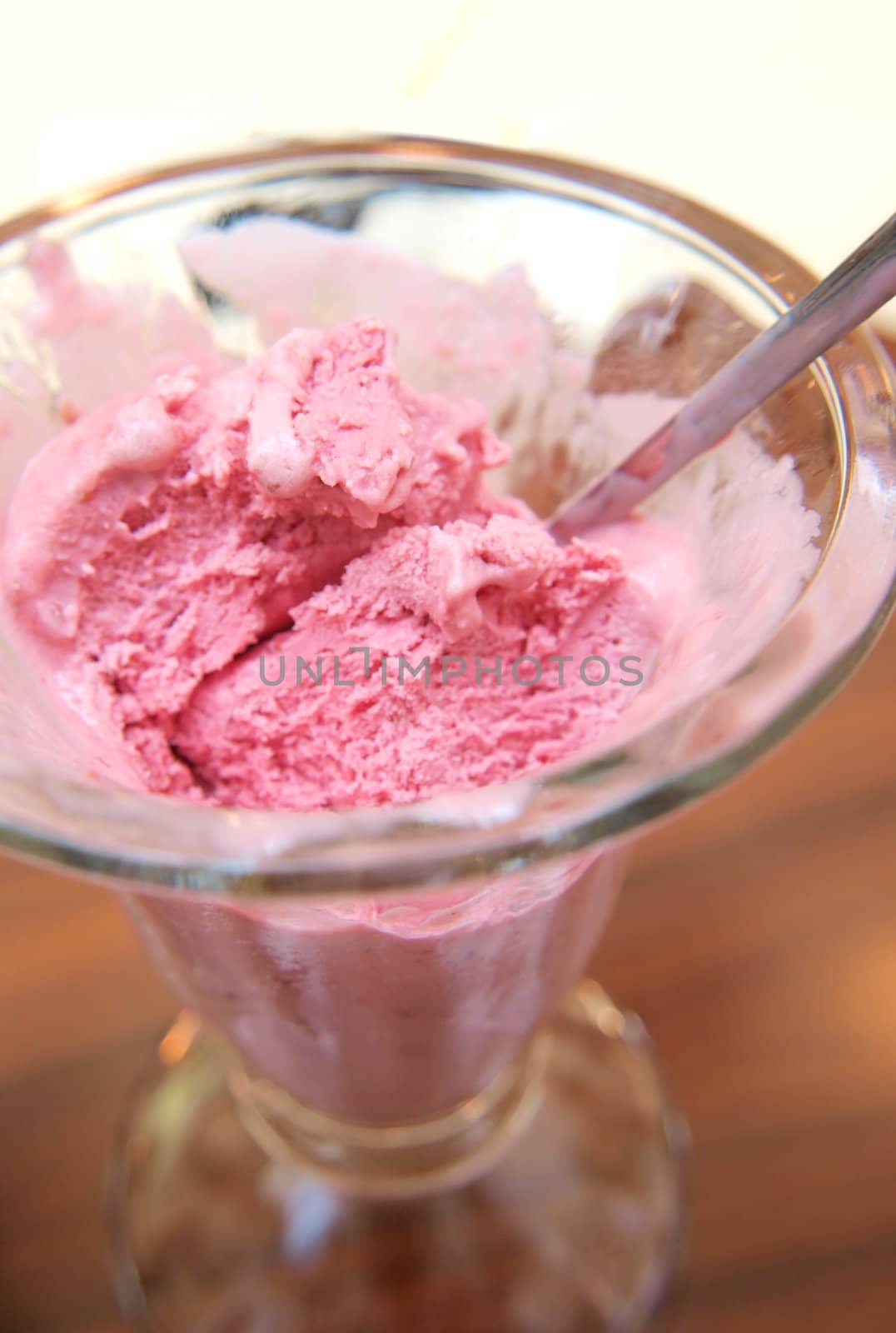 Pink ice cream in glass bowl, closeup
