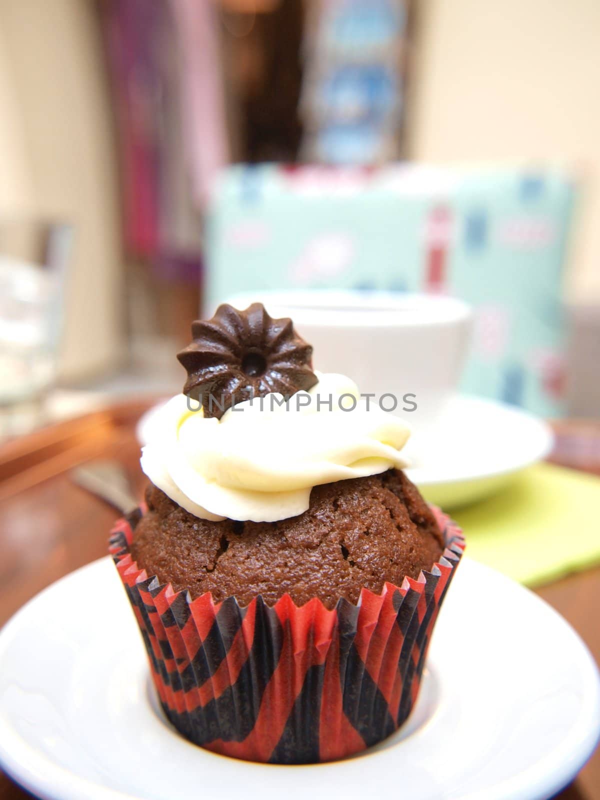 Closeip of chocolate muffin with icing, on plate by Arvebettum