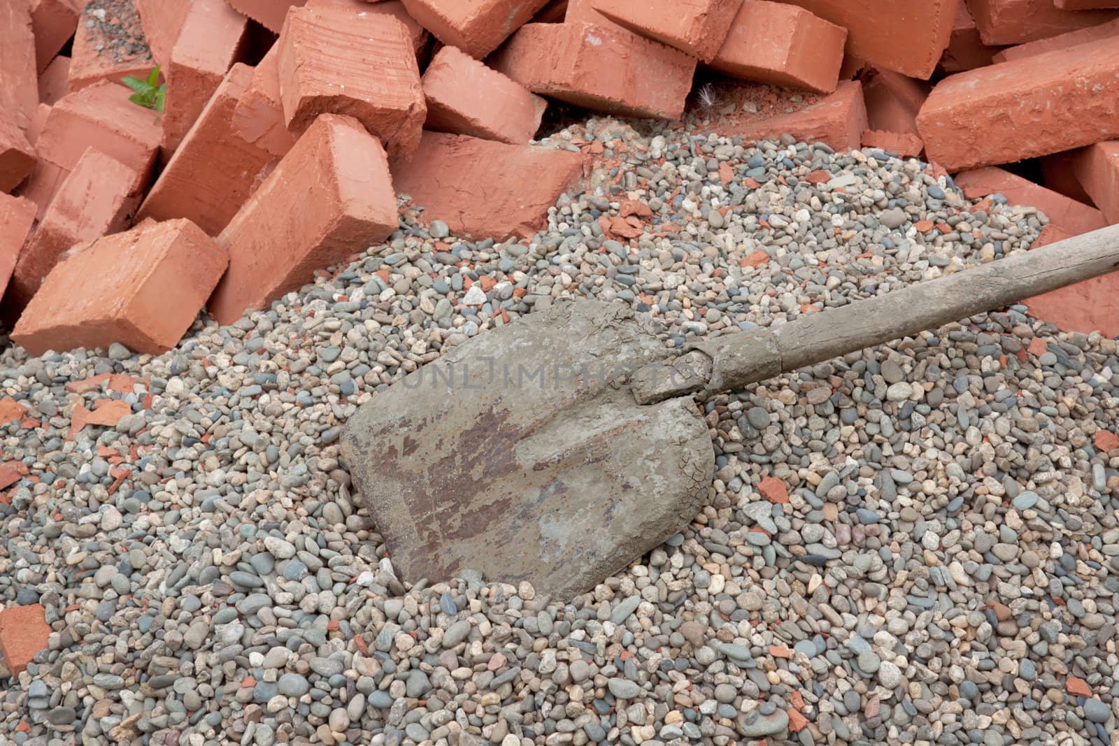 Lots red clay bricks lying on the gravel