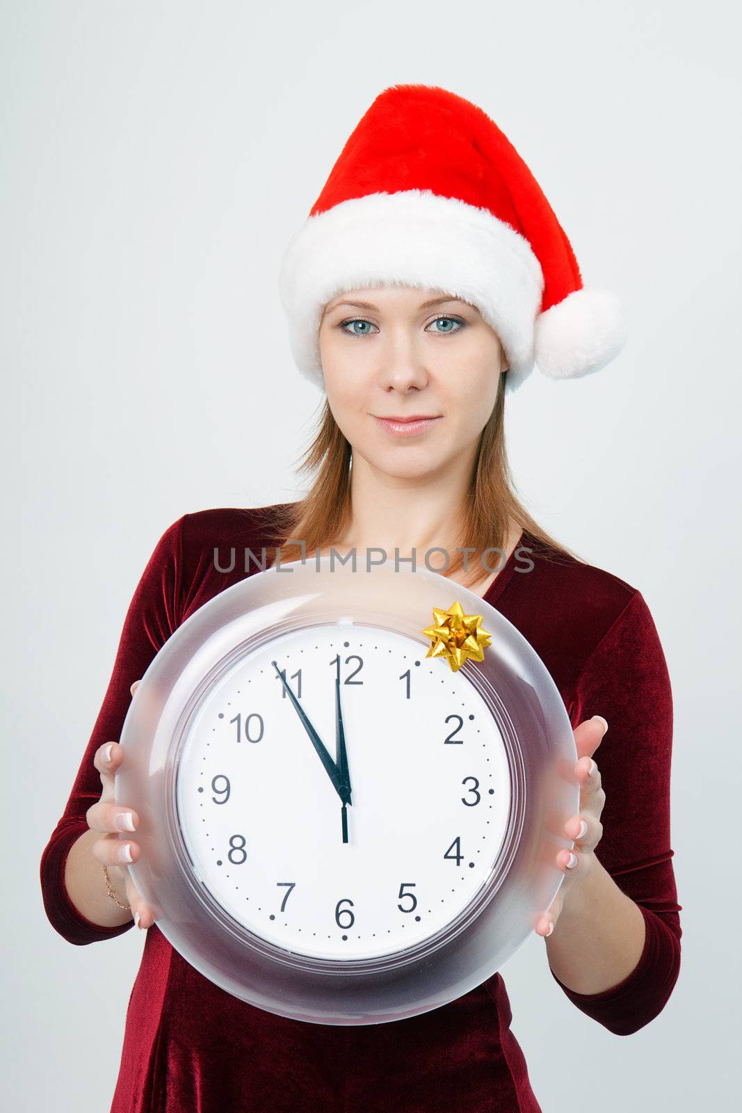 Christmas Eve. A young attractive girl with a clock