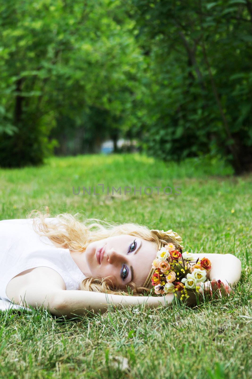 Romantic woman lying down on grass dreaming