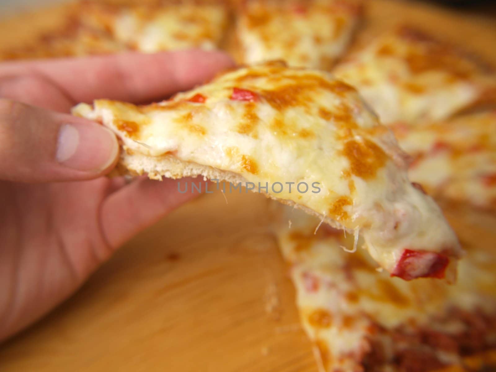 Slice of pizza, held up by a person by Arvebettum