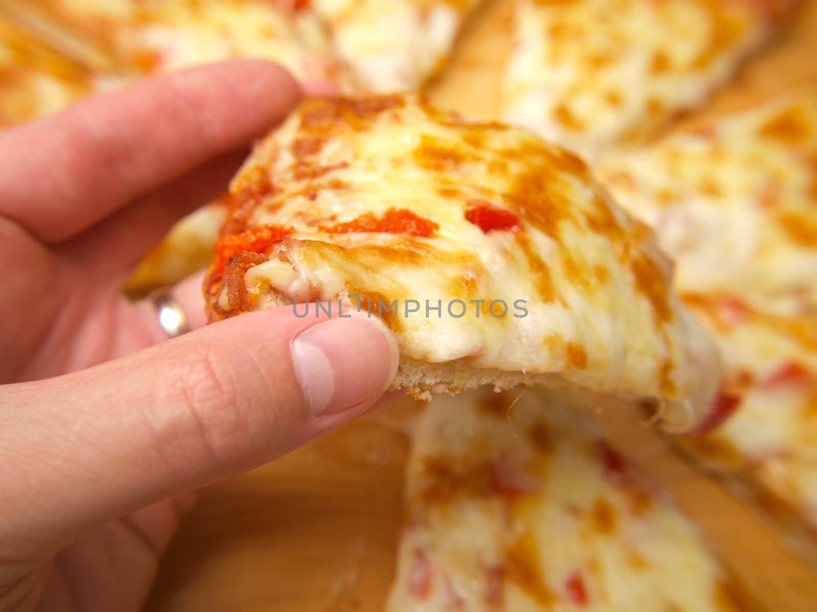 Slice of pizza, held up by a person by Arvebettum