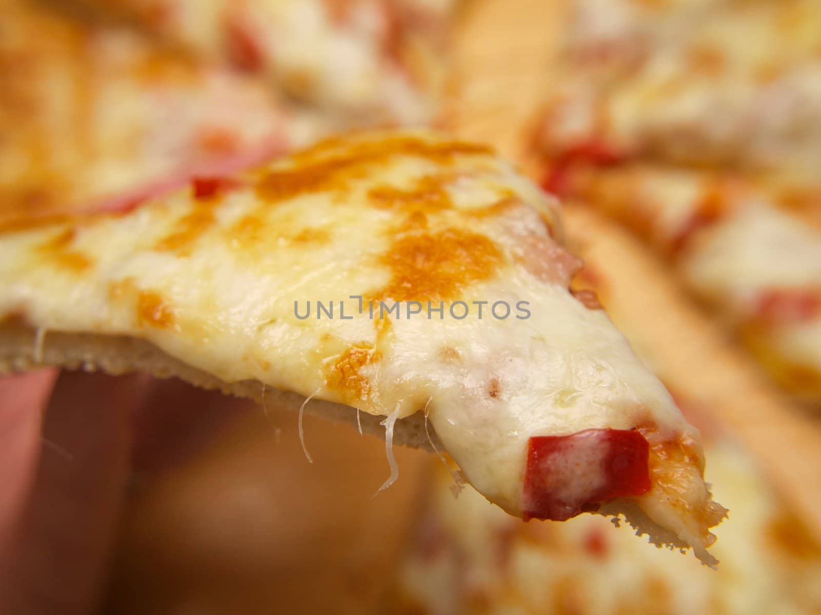 Slice of pizza, held up by a person by Arvebettum
