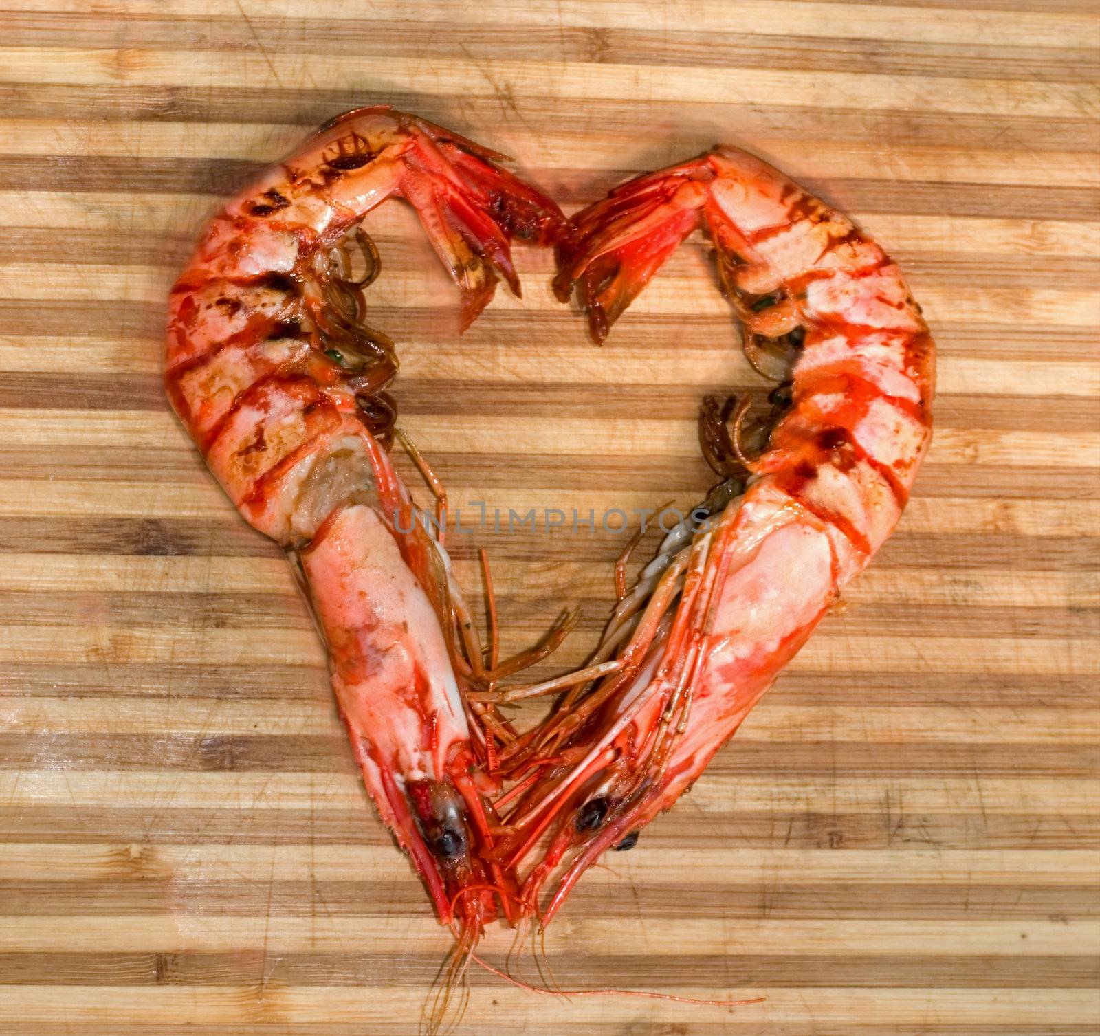 prepared shrimp forming a heart on striped wood texture