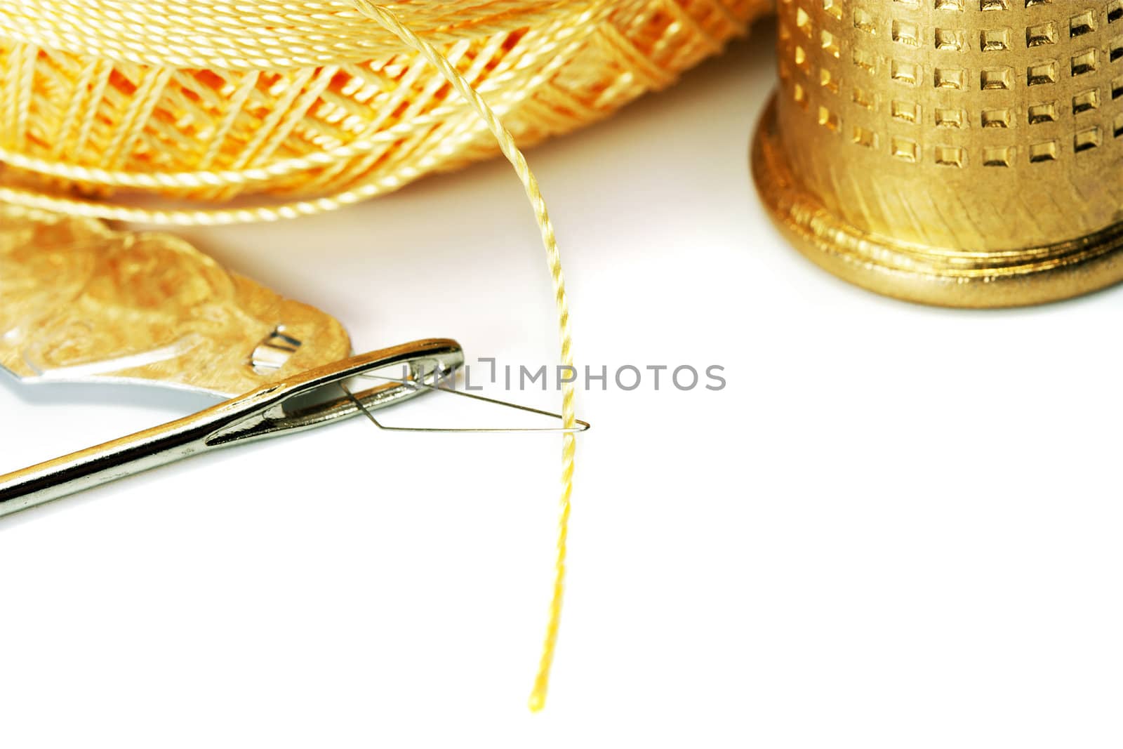 Thread in needle thimble isolated on white background