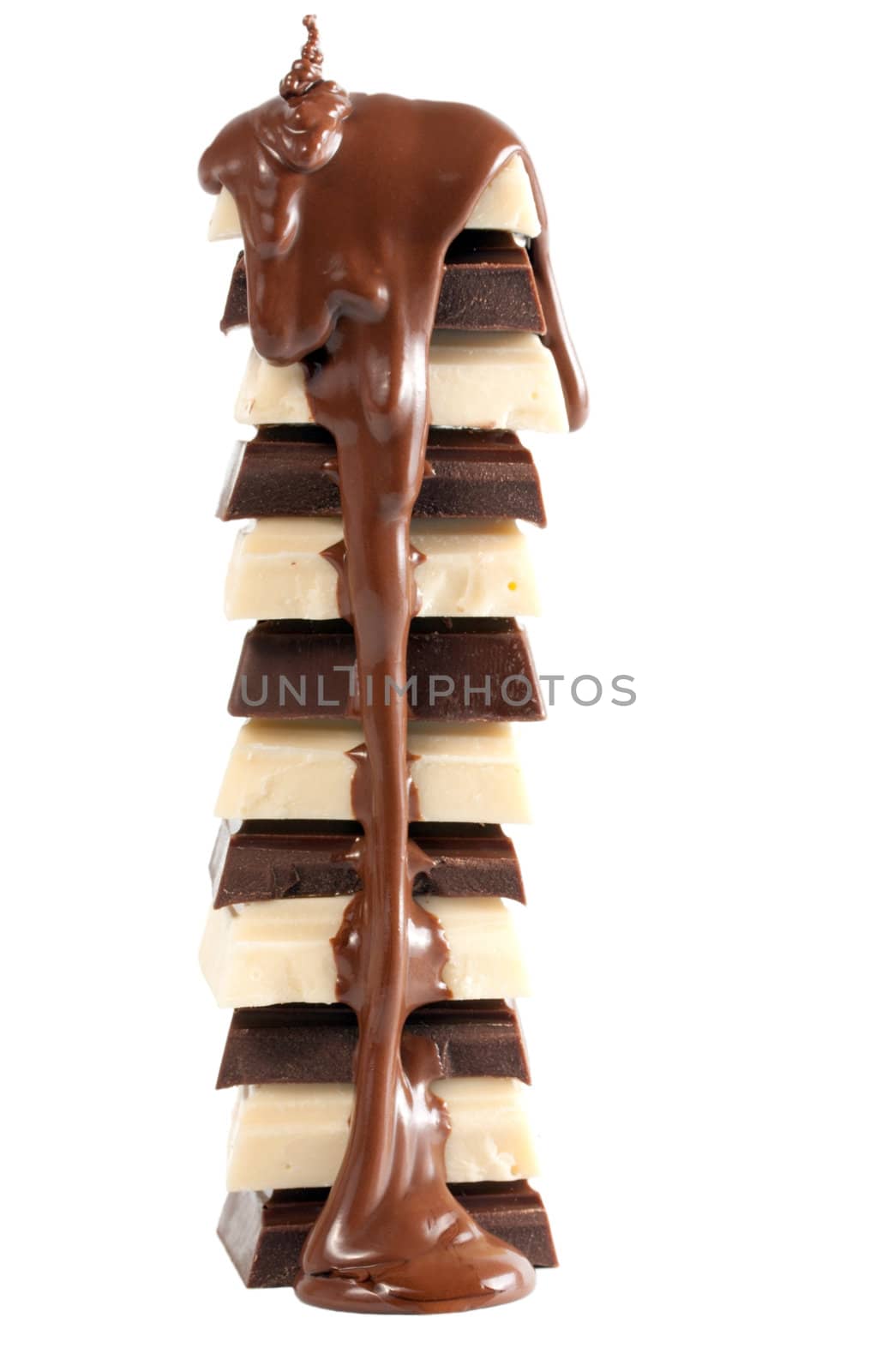 Pouring chocolate on stack of chocolate pieces isolated on a white background