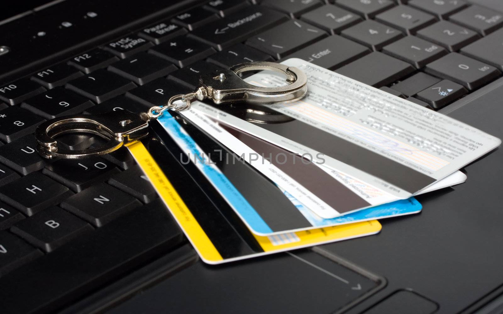 credit card of handcuffs on a computer keyboard