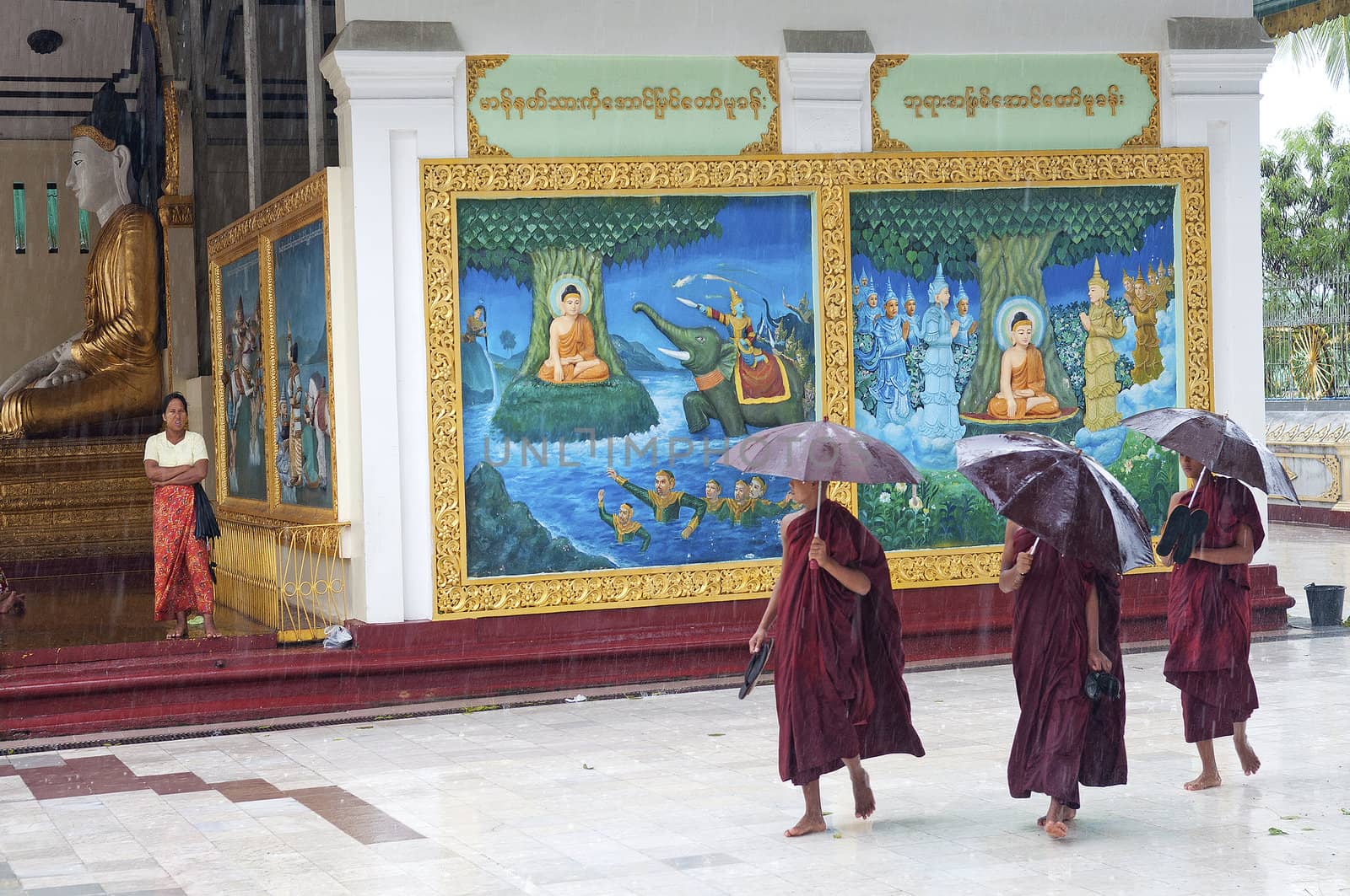 monks in rain at shwedagon paya temple yangon myanmar by jackmalipan