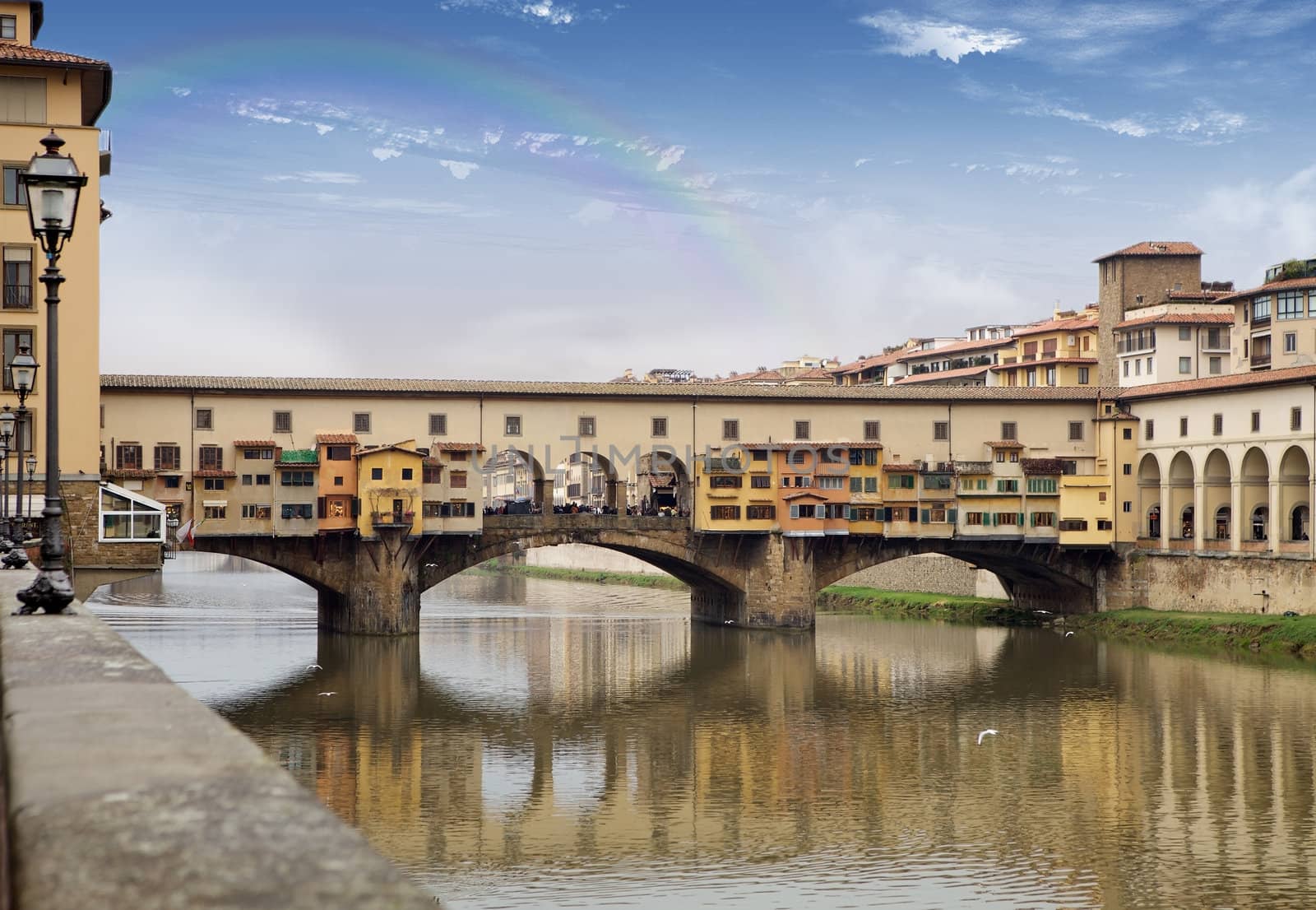 Florence, Italy: Ponte vecchio, Old Bridge, on the Arno river with rainbow in the sky in the background