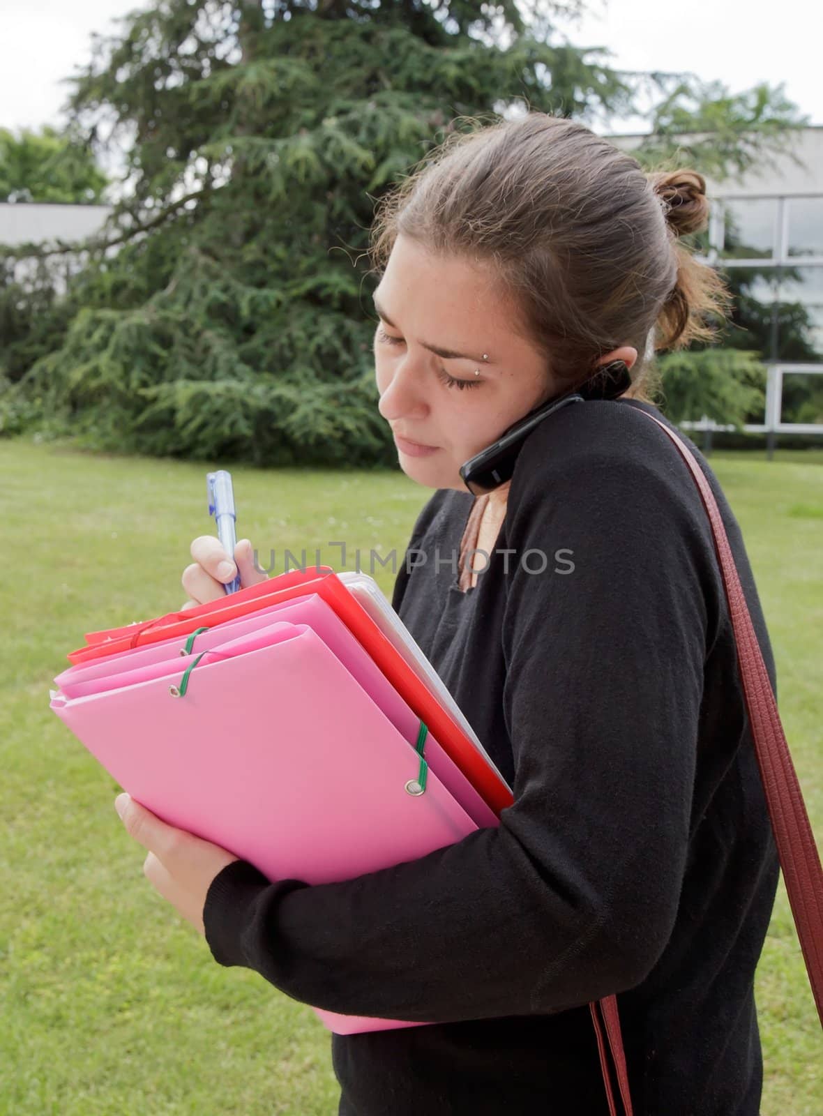 business woman on the phone, taking notes outdoors