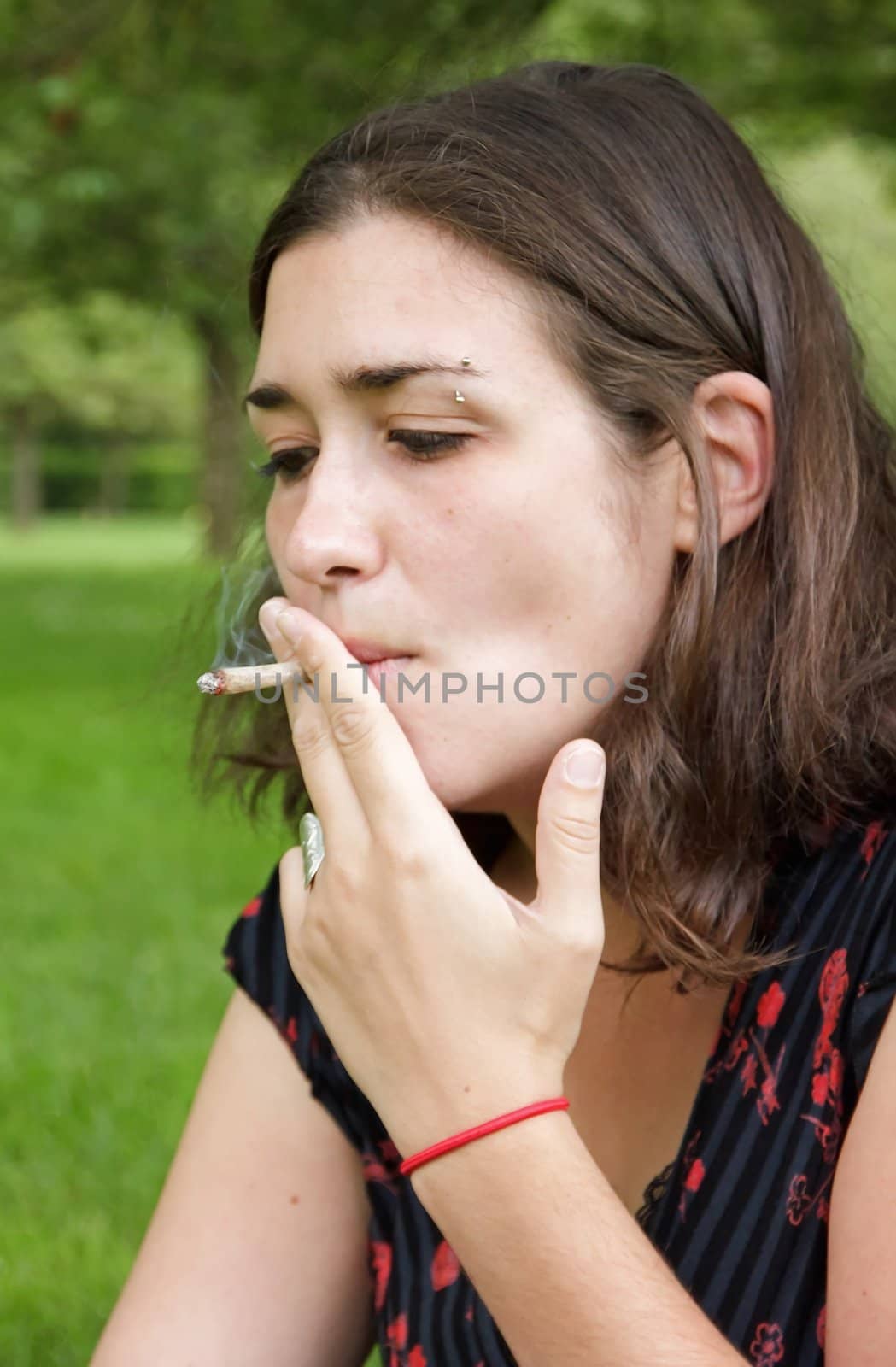 woman smoking outdoors, a rolled cigarette