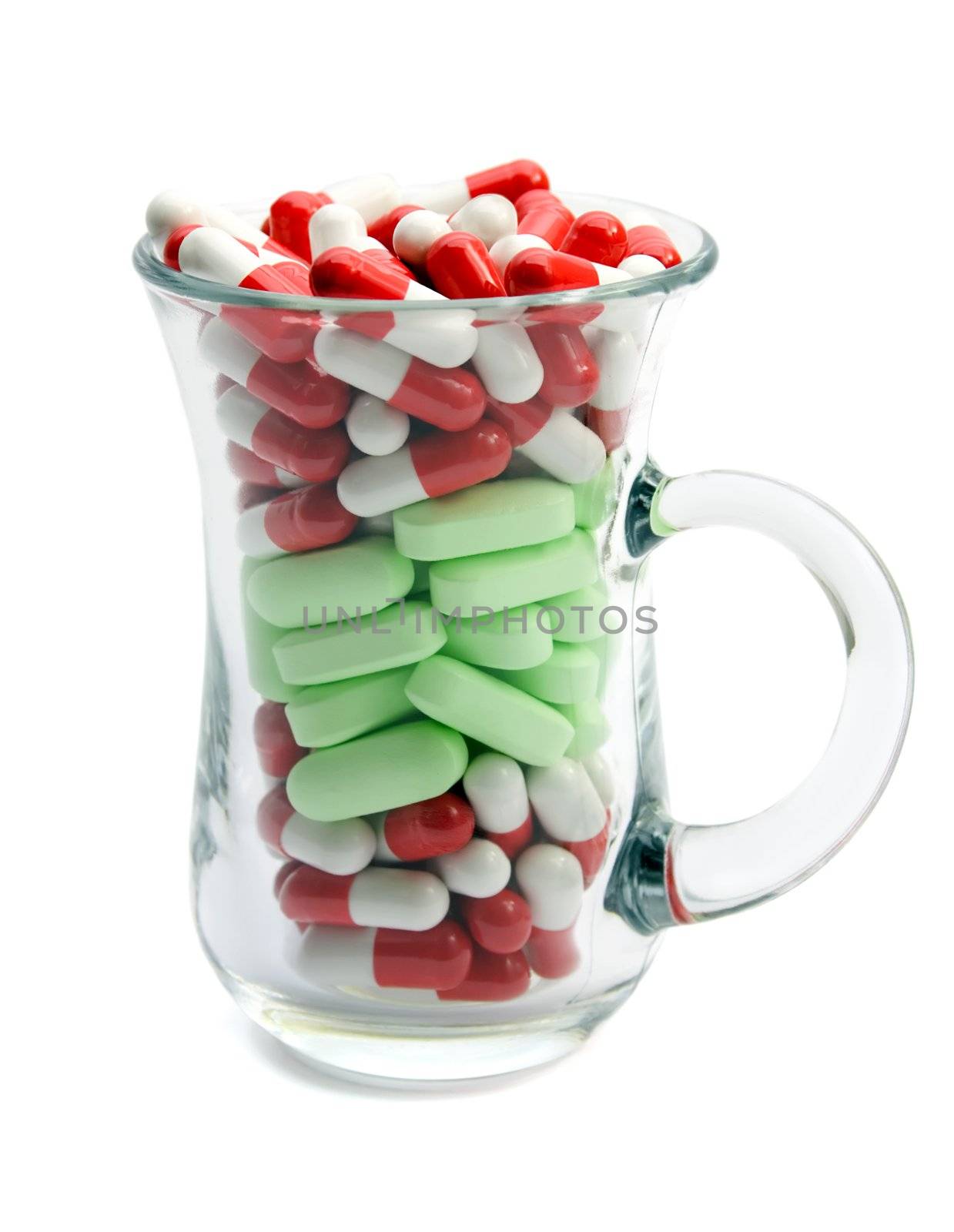 capsules and pills in cup glass isolated on white background