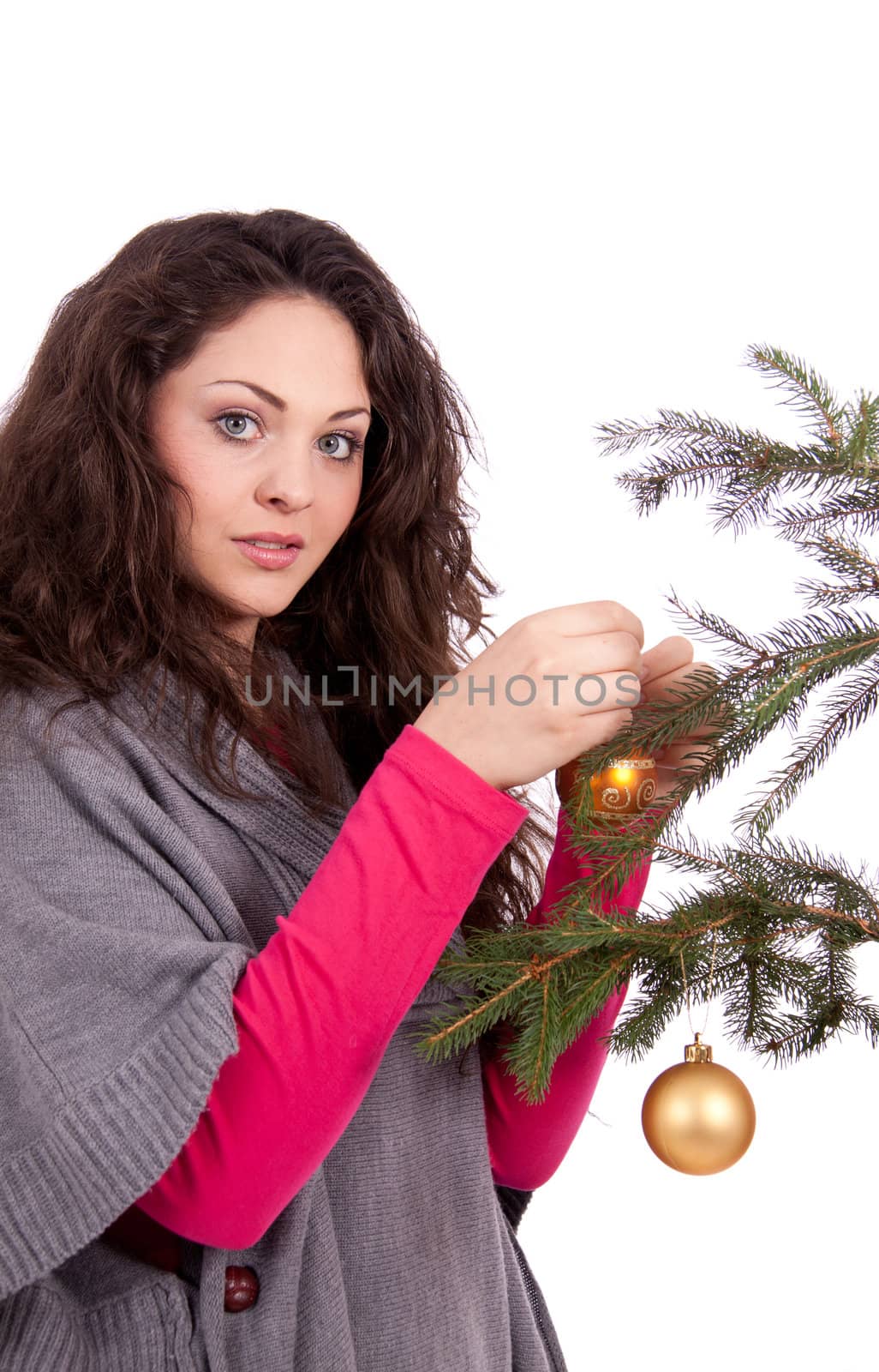 beautiful brunette woman is decorating a christmas tree isolated on white
