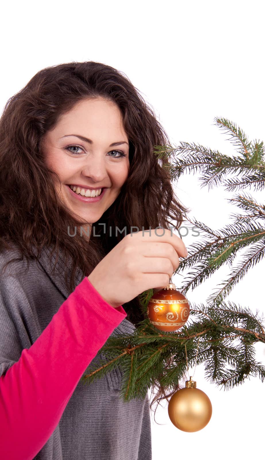 beautiful brunette woman is decorating a christmas tree isolated on white