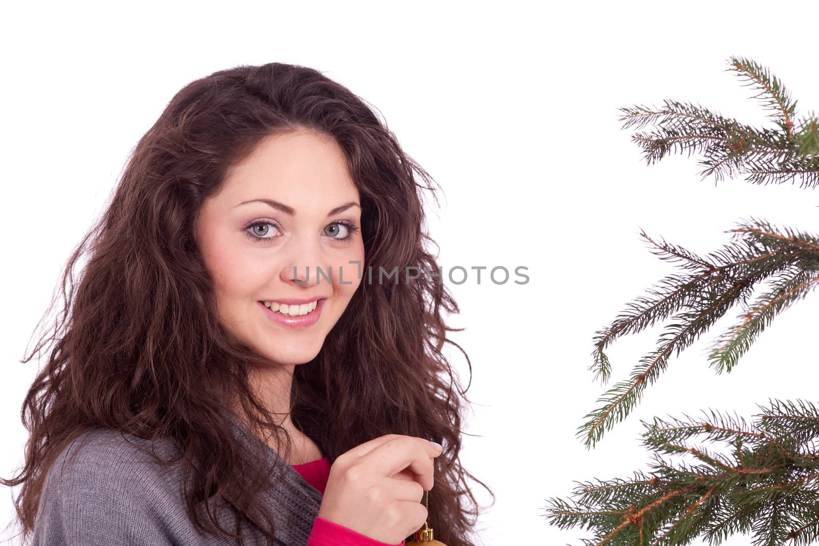 beautiful brunette woman is decorating a christmas tree isolated on white