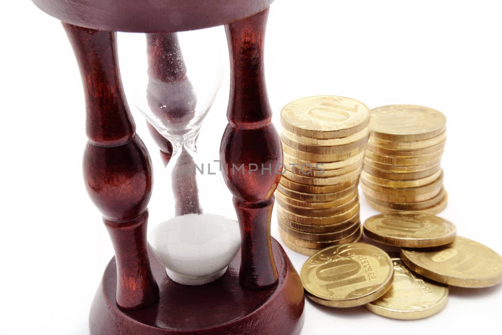 Brown wooden sandglass and coins over white background