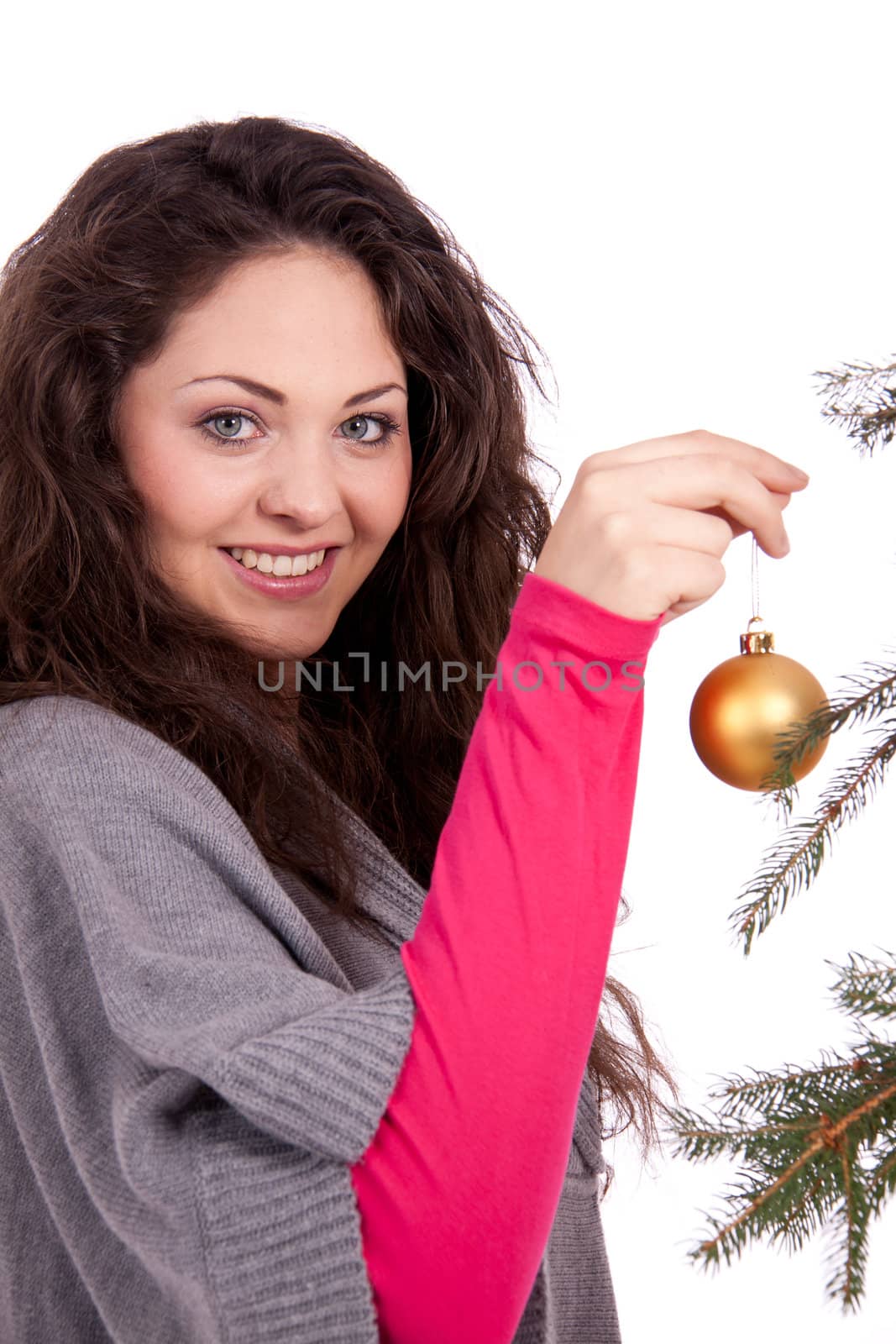 beautiful brunette woman is decorating a christmas tree isolated on white