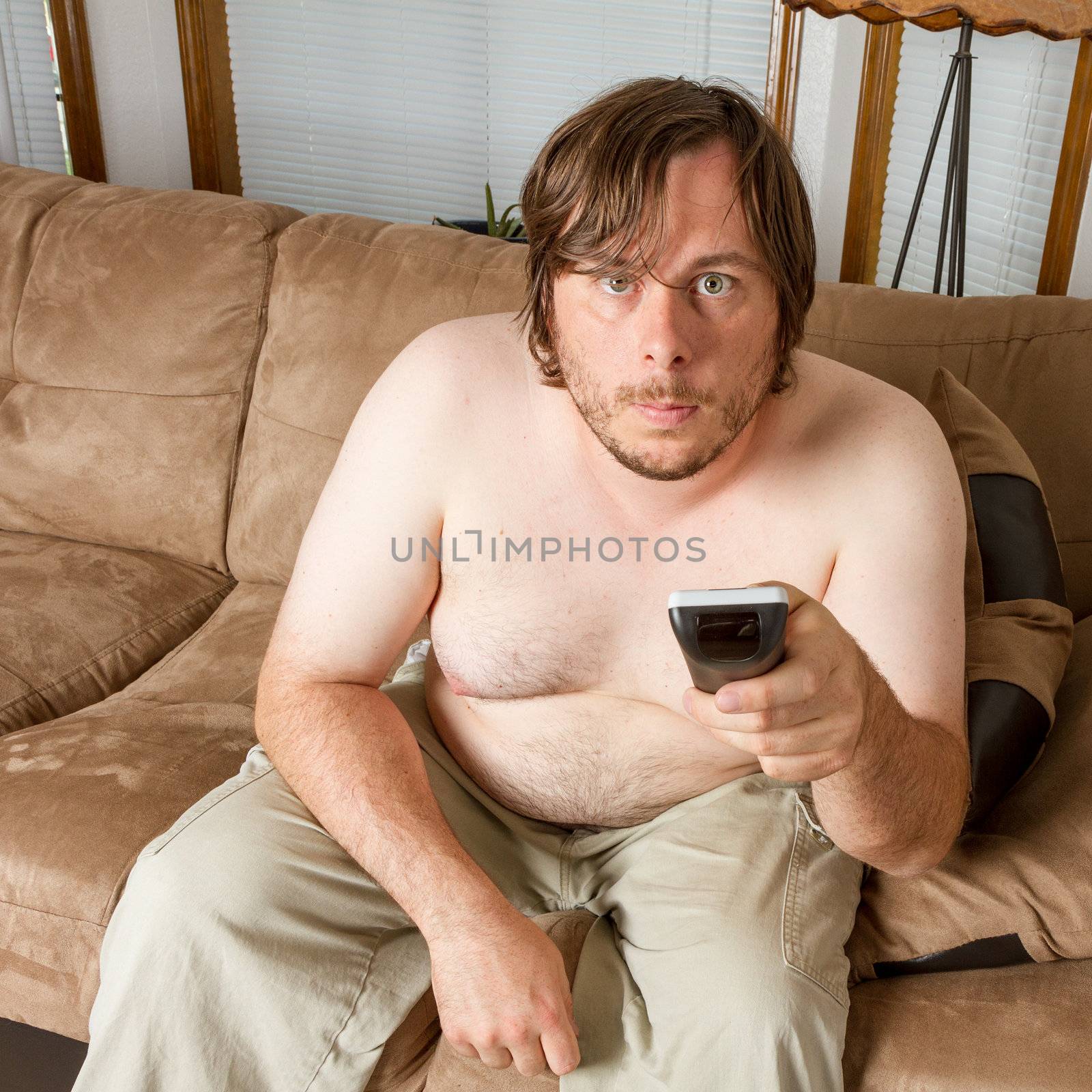Man playing the lazy role of the couch potato