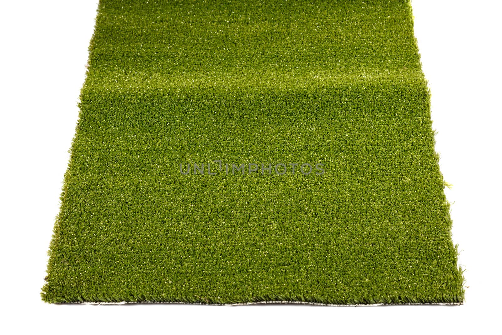 a piece of green artificial grass on a white background