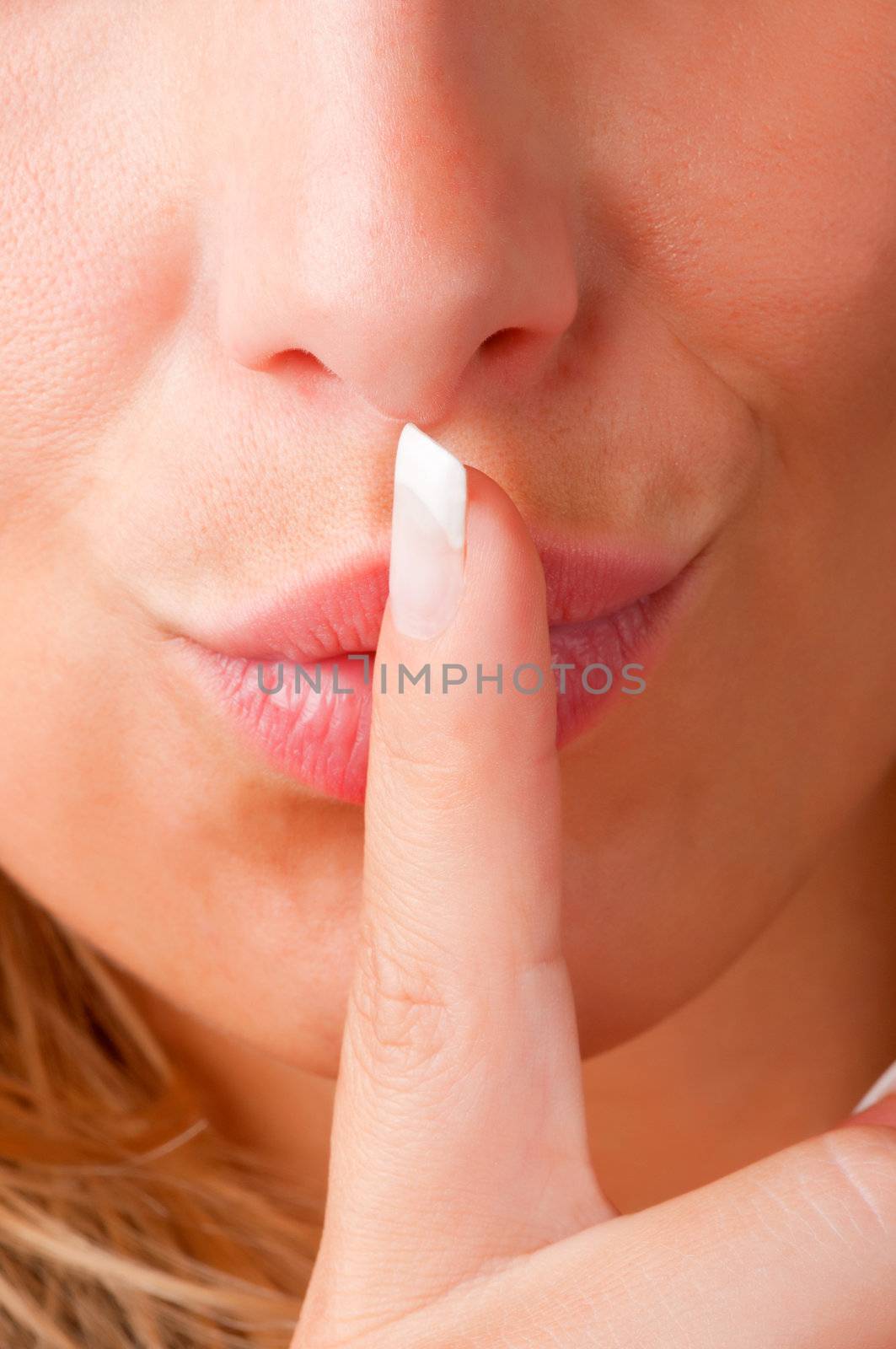 Closeup of a woman with her finger over her mouth