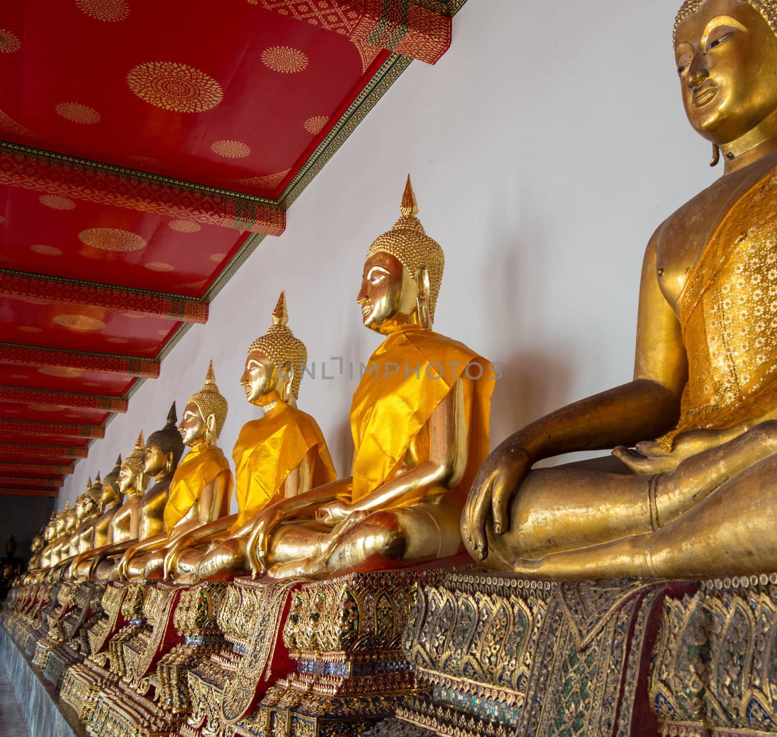 Many golden buddha statues in Wat Po temple near Bangkok in Thailand