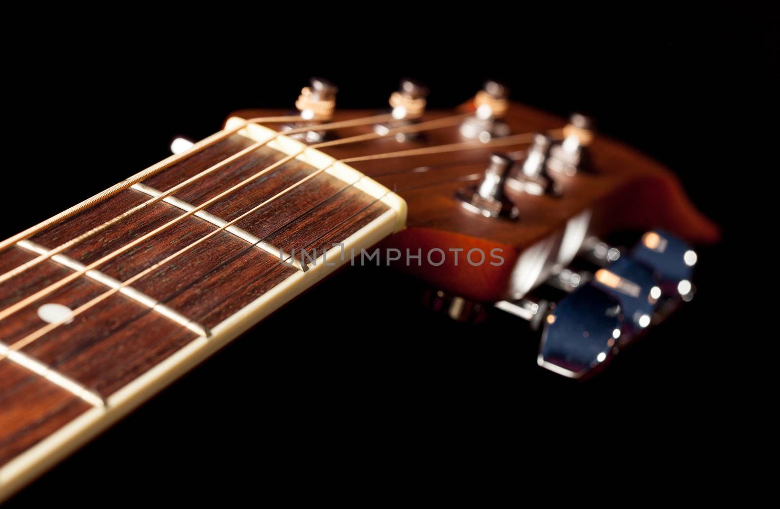 Macro shot down the fretboard of acoustic guitar with shallow depth of field
