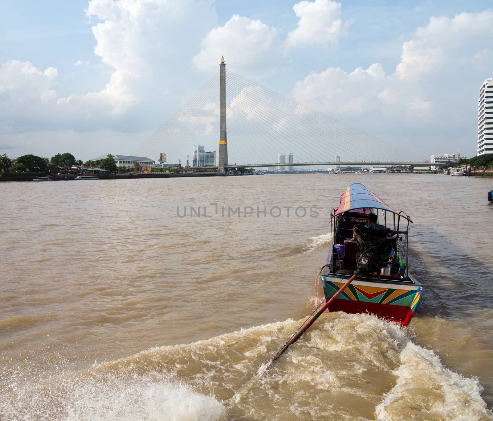 BANGKOK, THAILAND - JUNE 23: Boat on Chao Phraya River by Rama VIII bridge on June 23, 2012. The bridge is 2.45km long.
