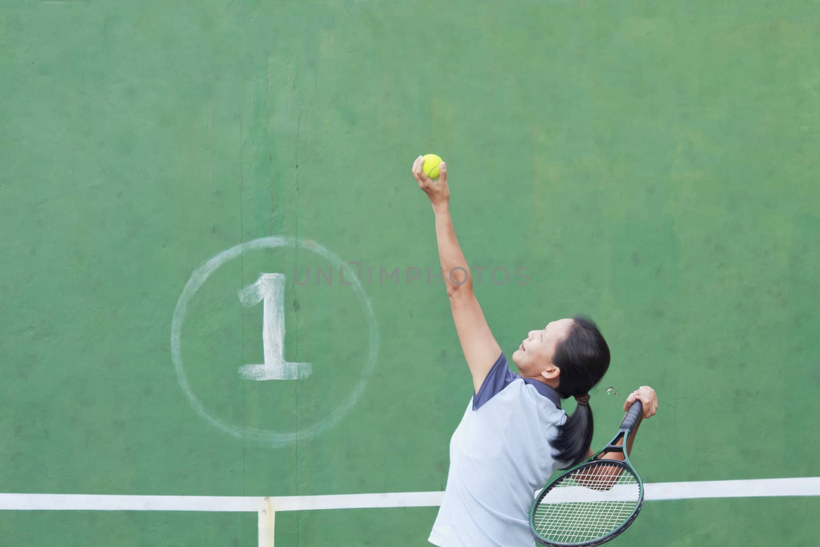 Female tennis player getting ready to serve