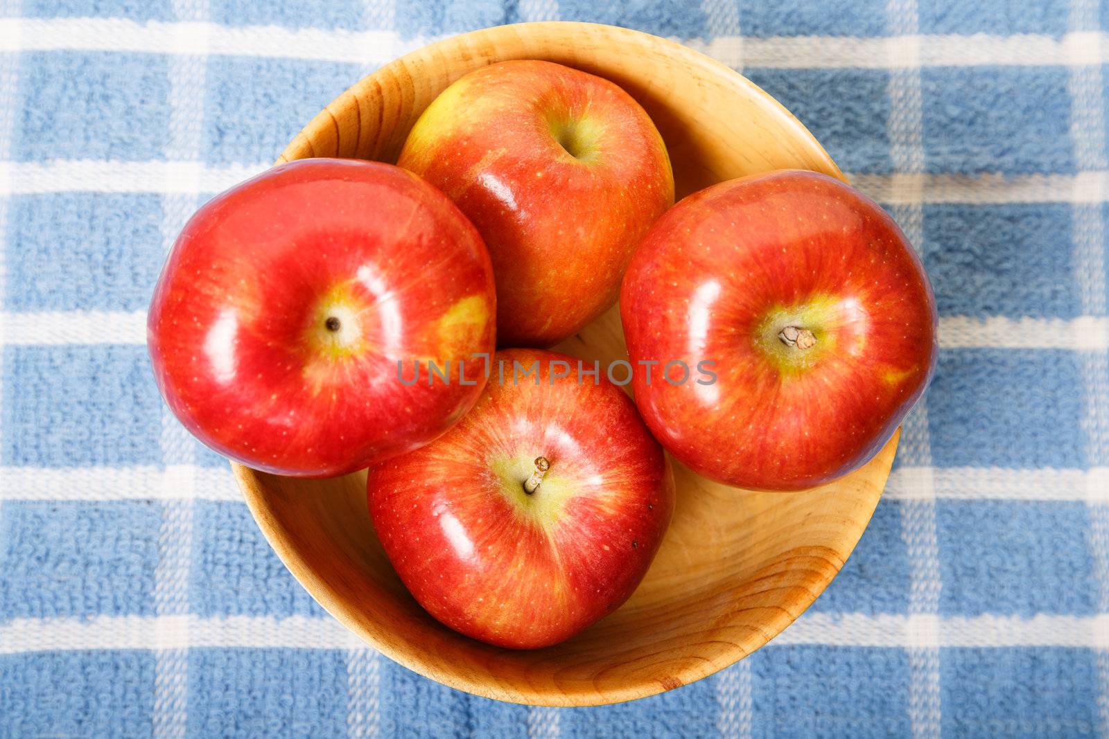 Red Apples in a Wood Bowl on Blue Plaid Placemat from Above
