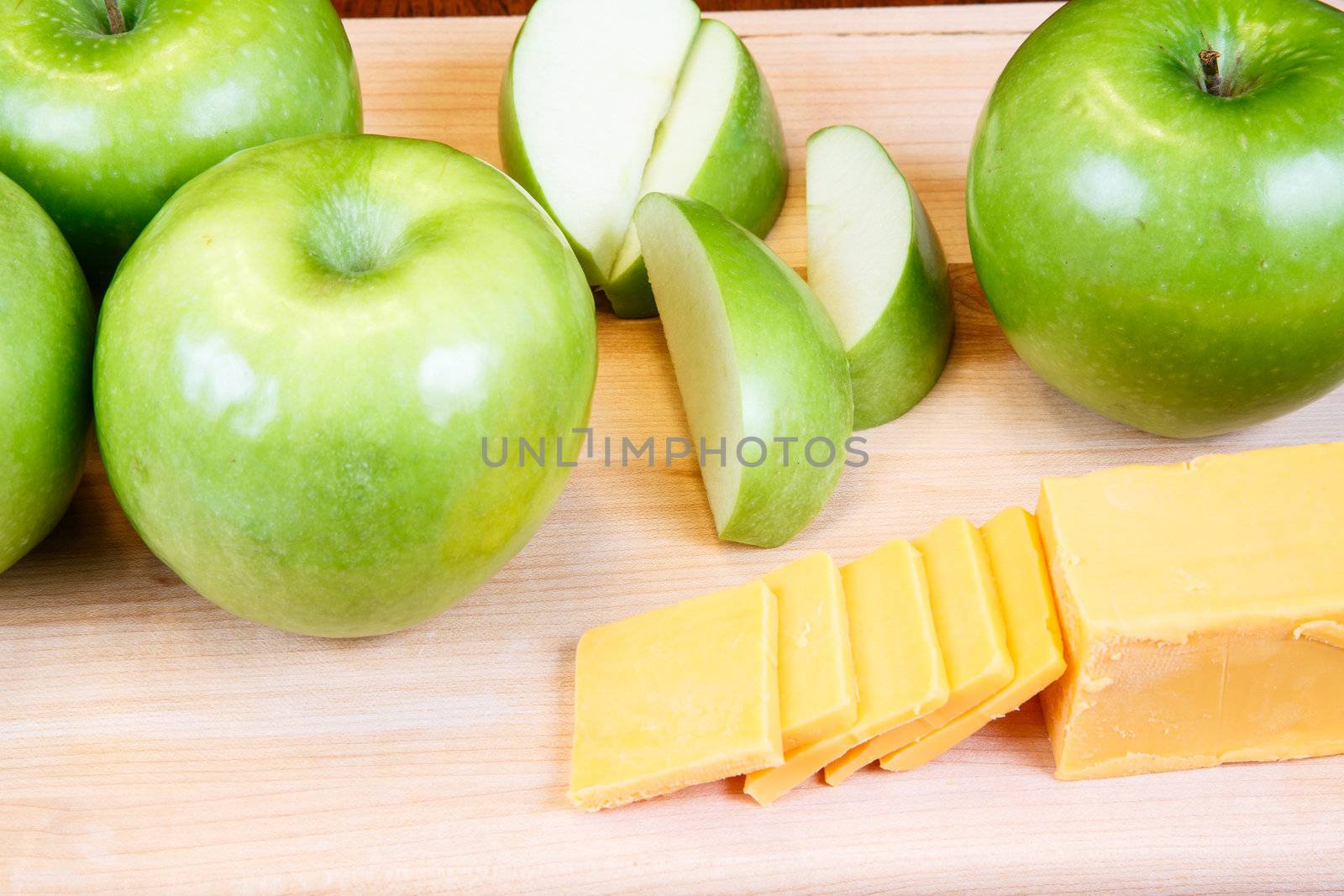 Cut and whole green granny smith apples with cheddar cheese