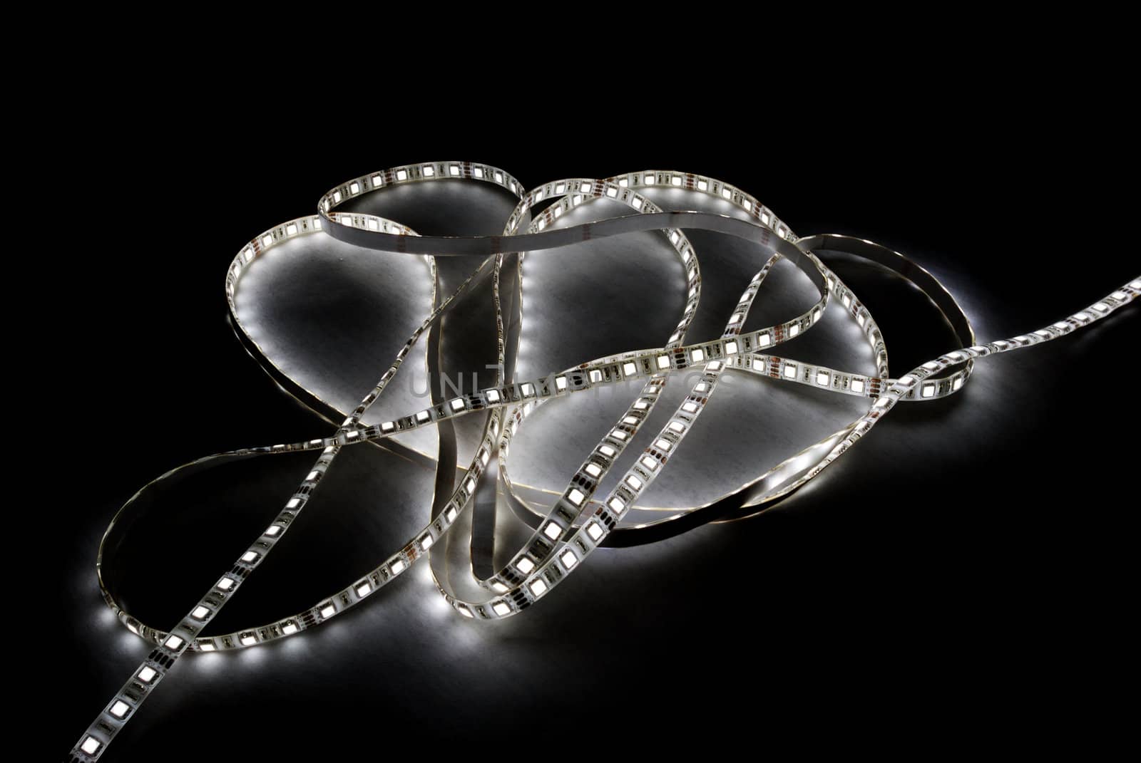 white led strip with a glue layer, background in the dark, illuminated by strip