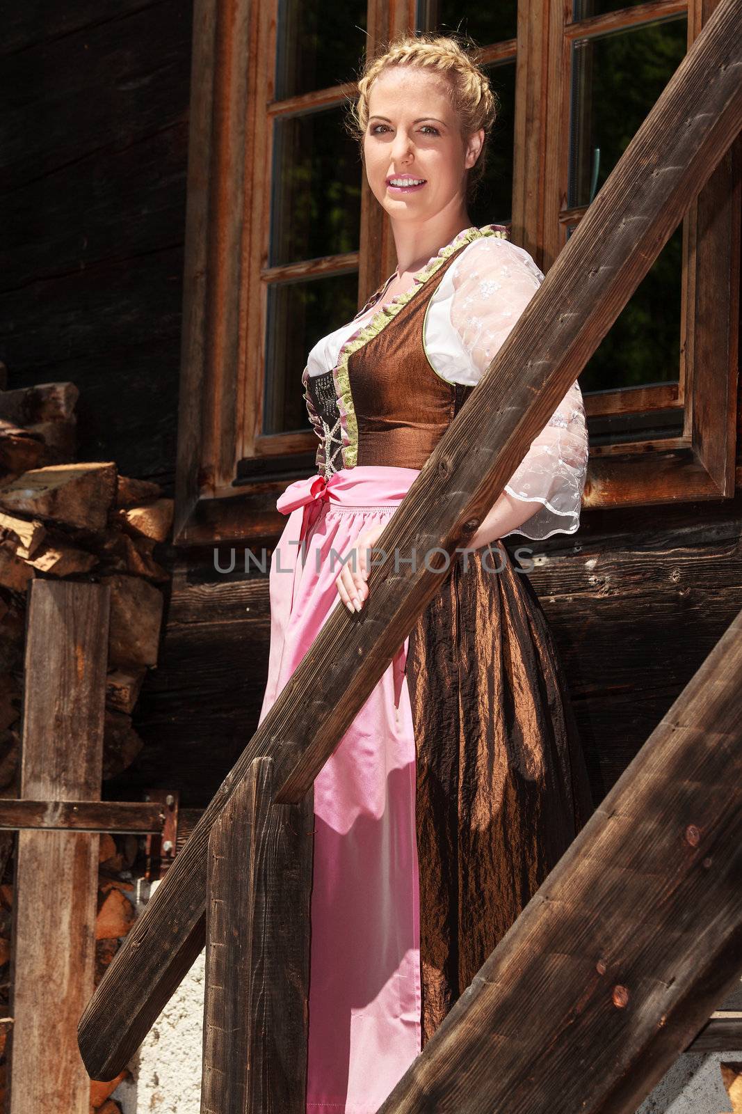 Bavarian girl is in festive costume on a mountain, stairs