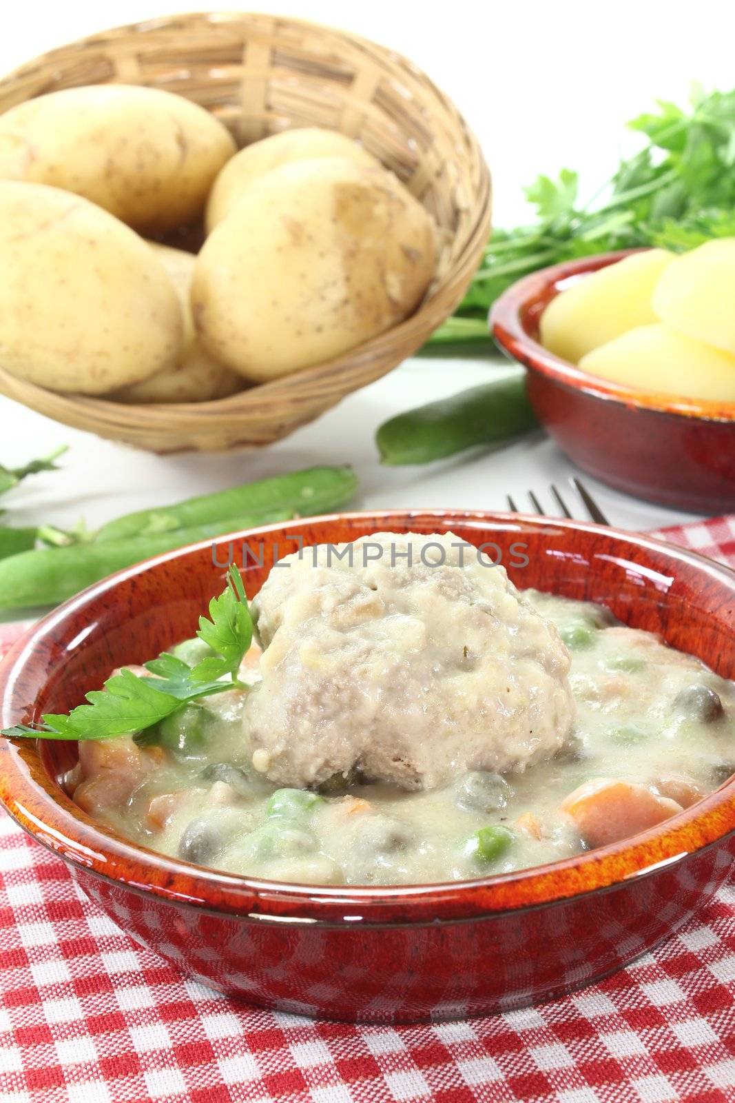 cooked meatballs in a white sauce with capers and potatoes by discovery