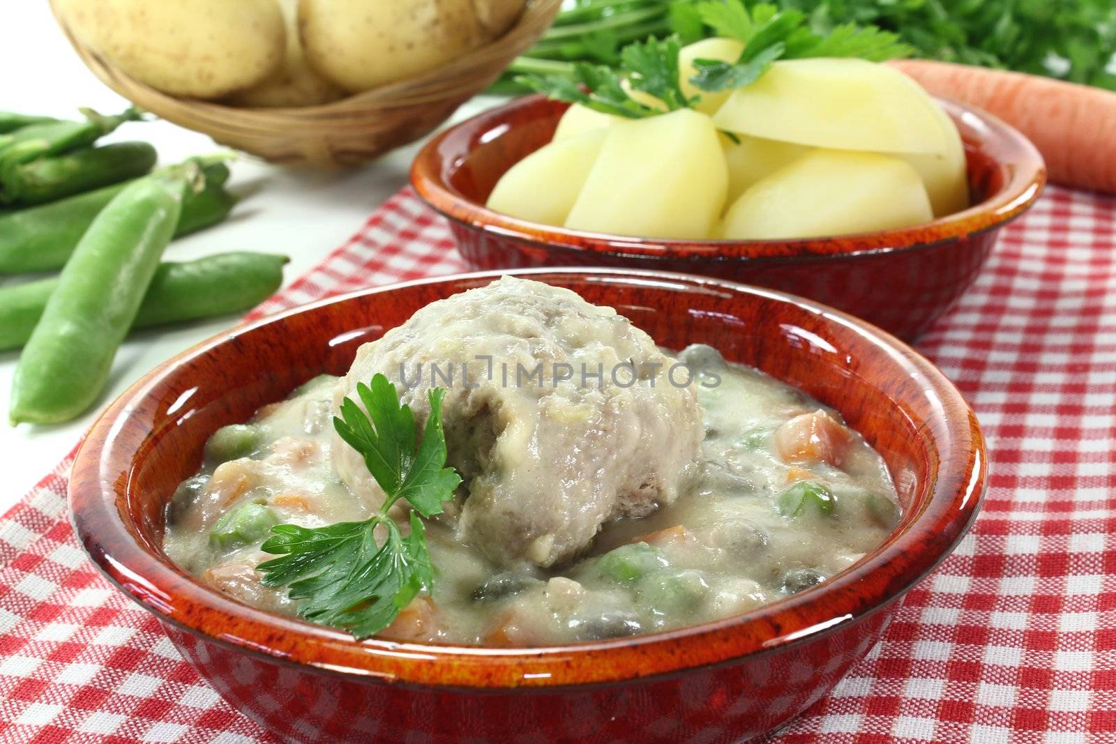 cooked meatballs in a white sauce with capers and parsley by discovery