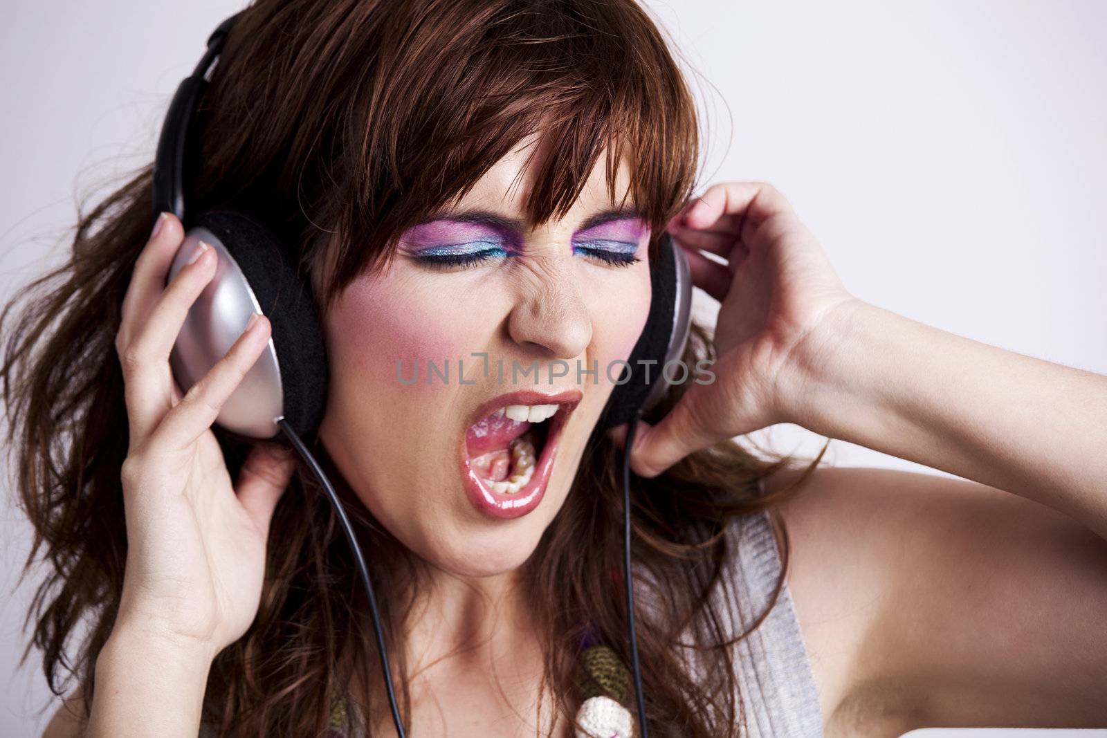 Studio fashion portrait of a young woman listen music