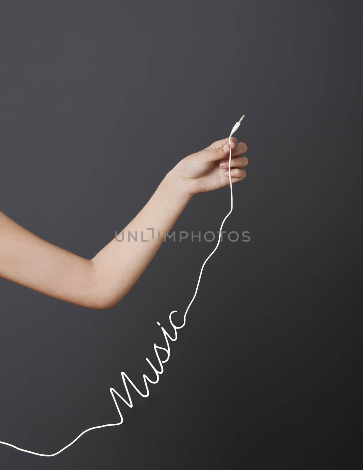 Hand holding a stereo audio cable with a shape of the word music