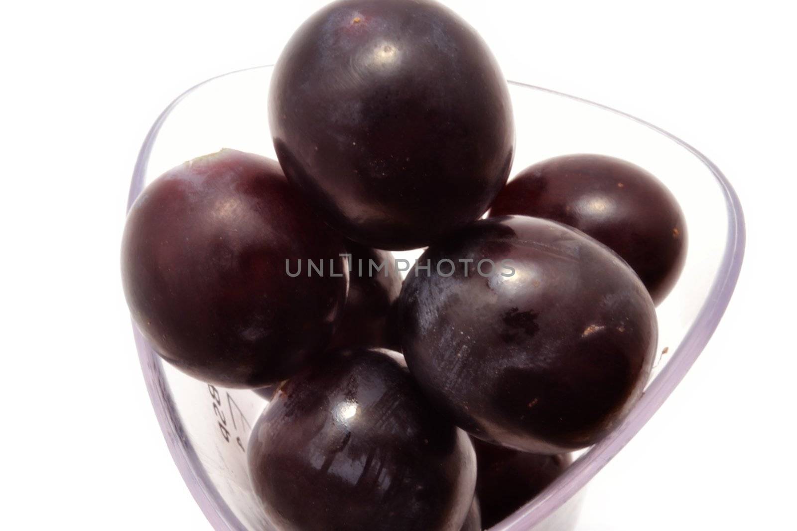 Top view of black grapes inside measuring glass