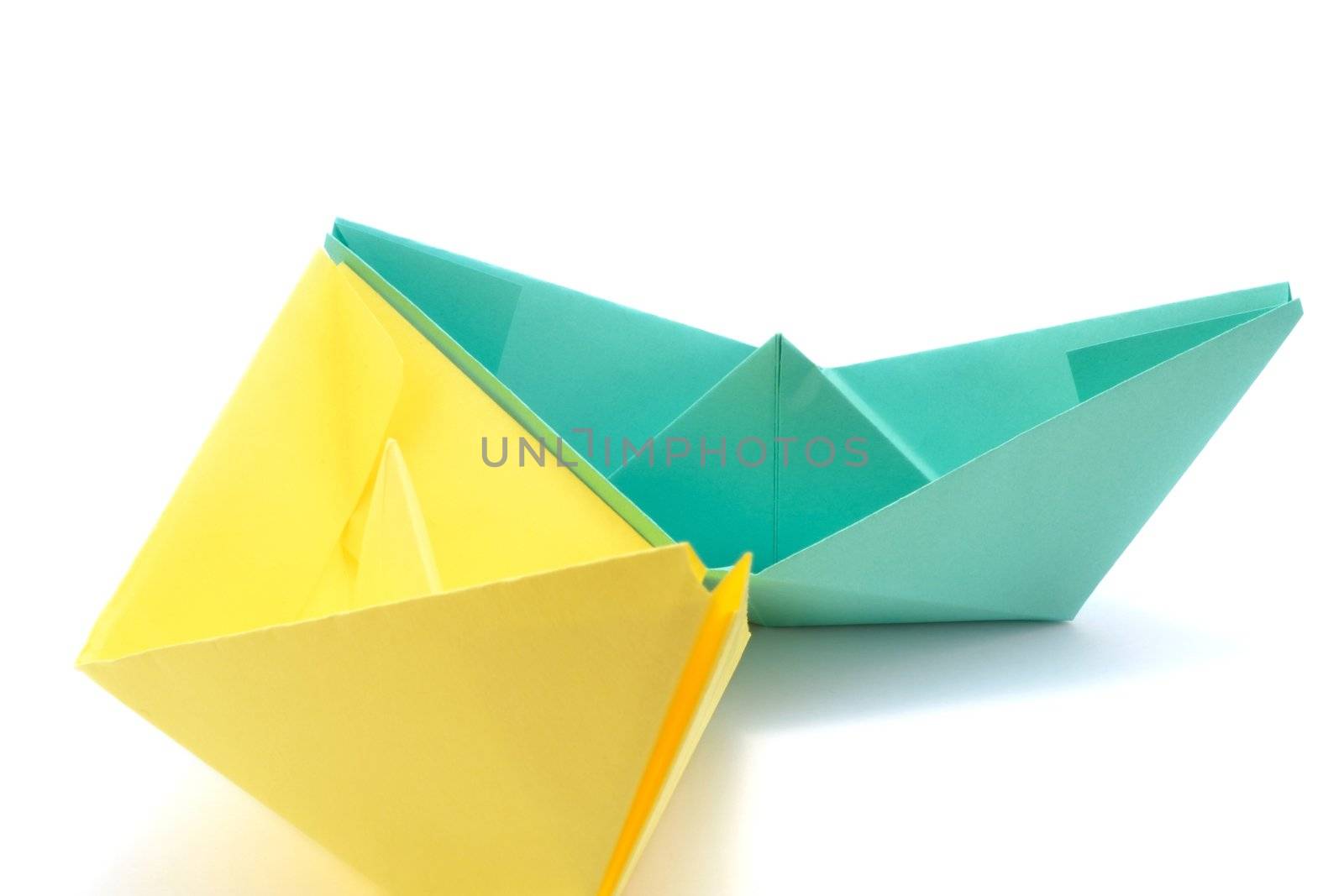 White paper ship and green paper ship isolated over white background