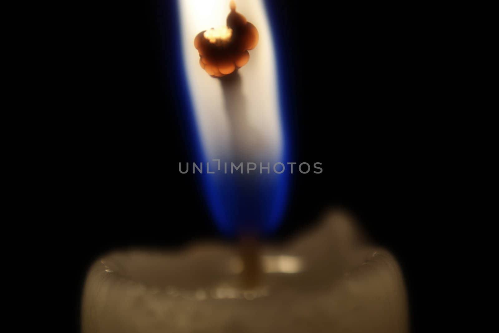 Burning candlewick isolated over black background