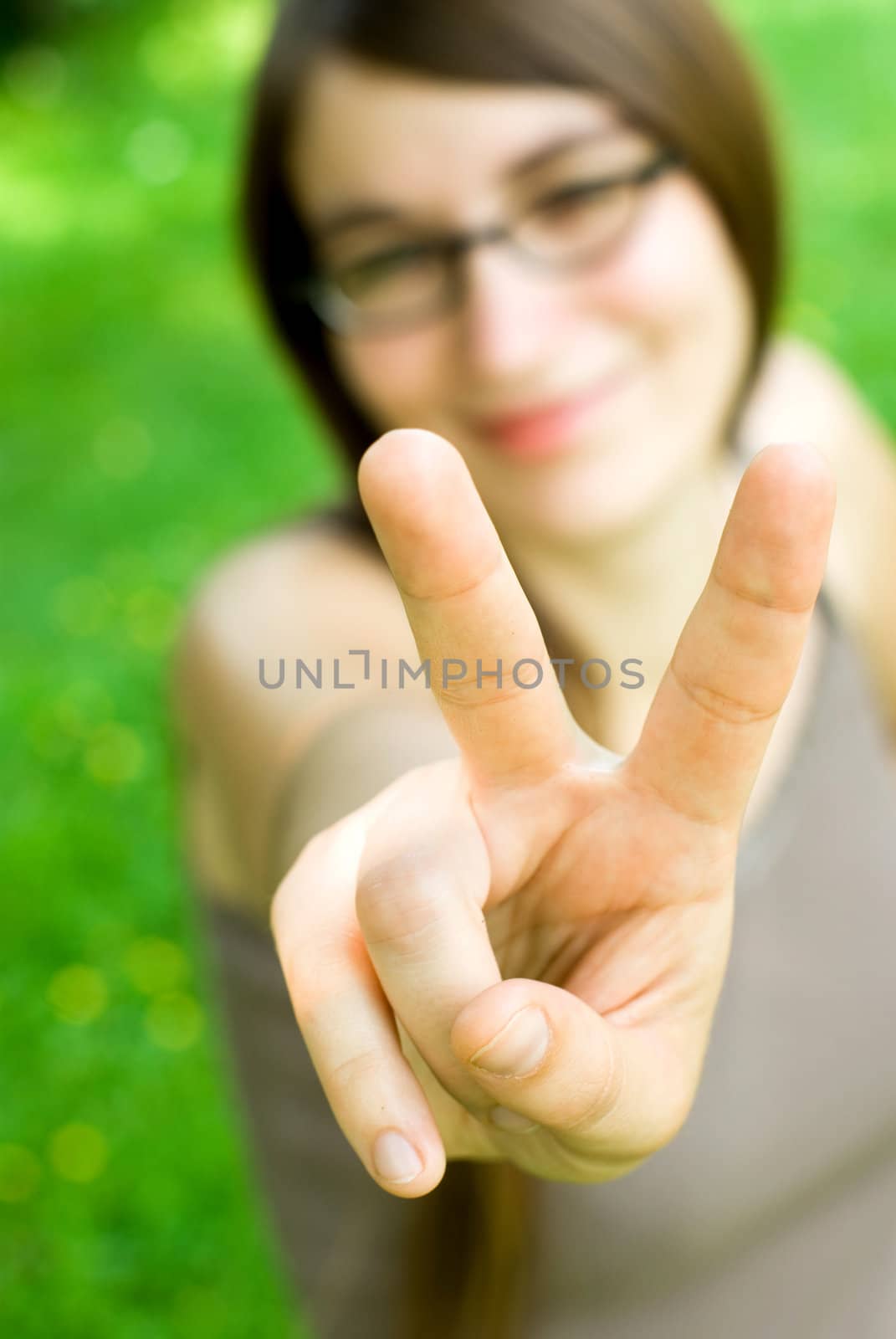 smiling girl making victory gesture by filmstroem