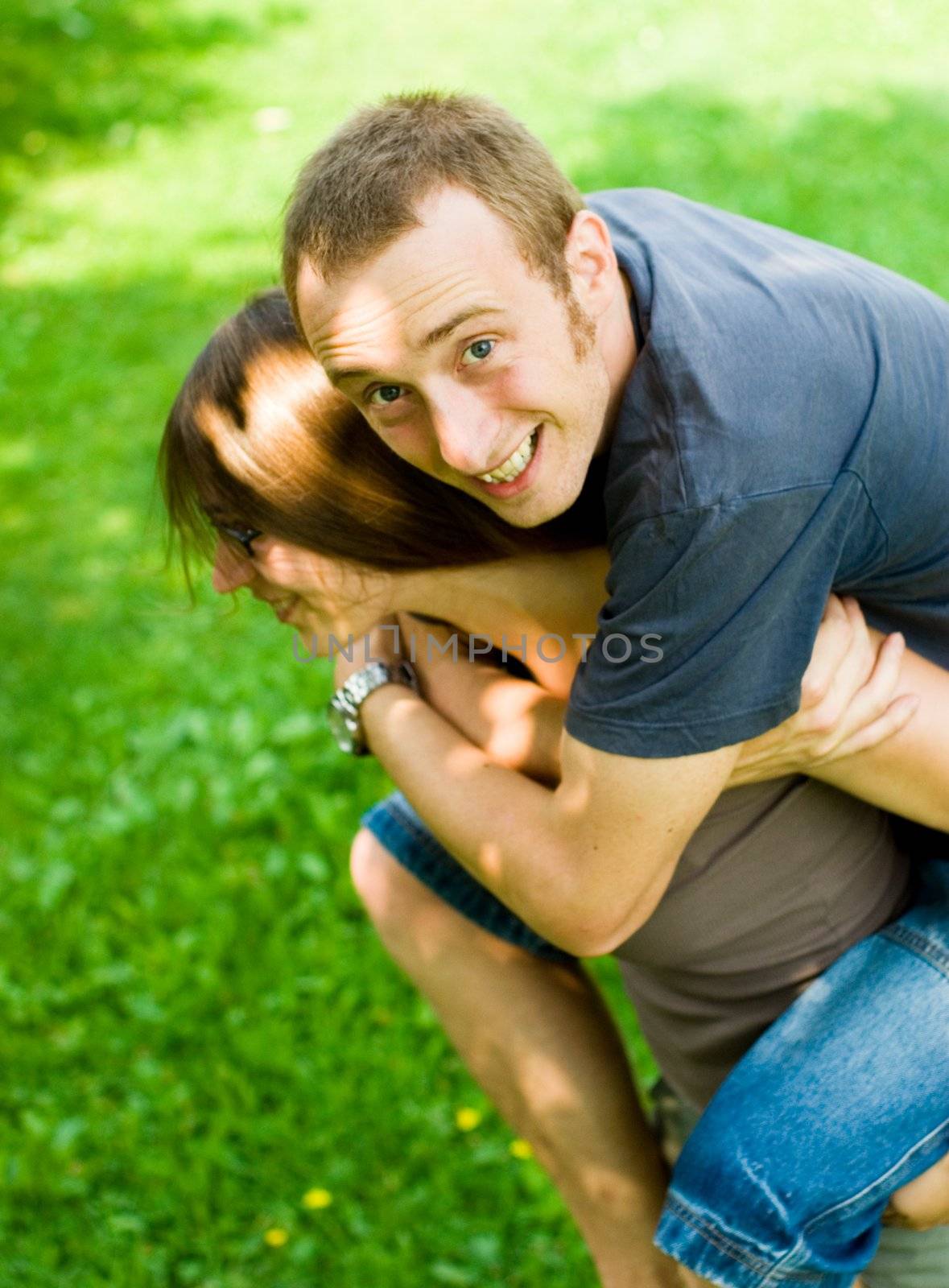happy young couple having fun outdoors doing piggyback rides with reversed roles