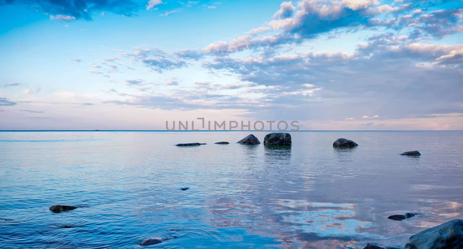 evening sea coast scene with rocks by filmstroem