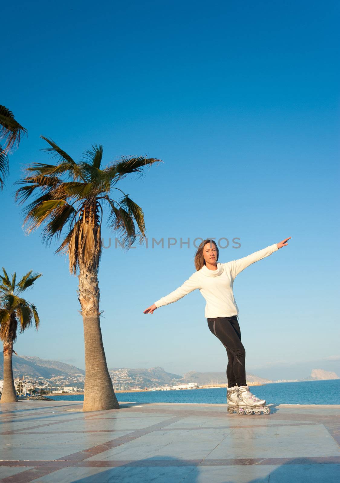 Having fun skating on a sunny Mediterranean beach promenade