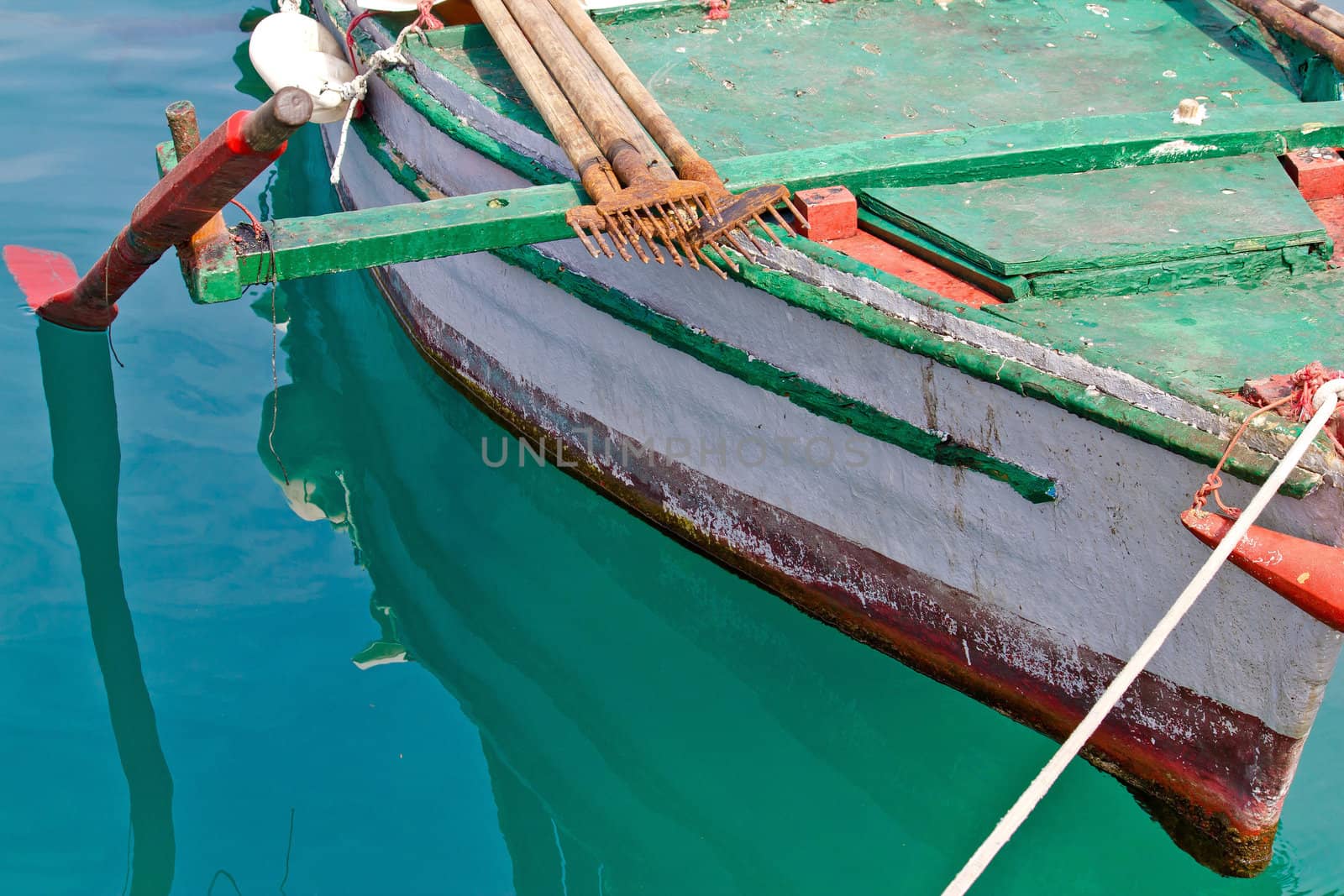 Old wooden colorful fishing boat detail with rusty fish gig