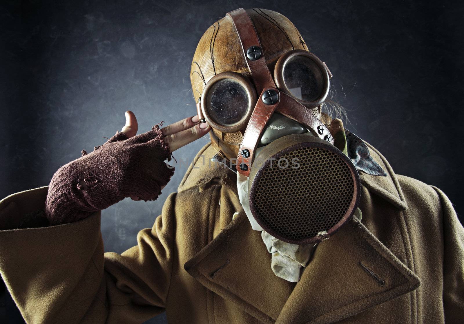 grunge portrait man in gas mask pointing hand gun at his own head, suicide