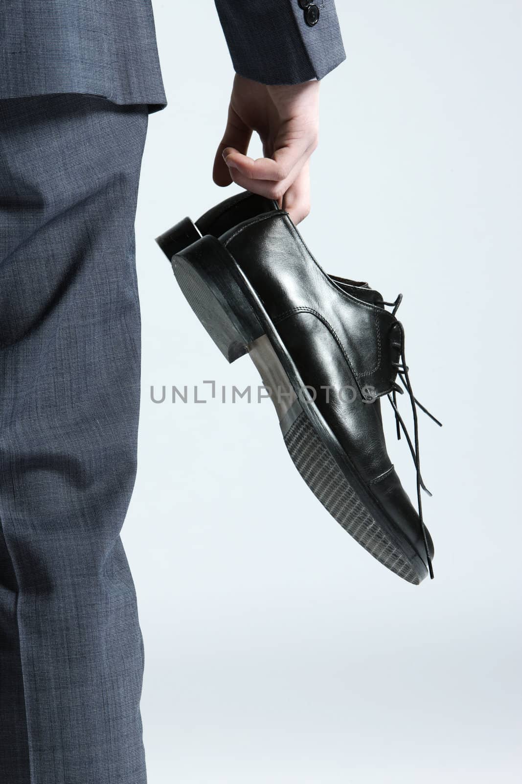businessman holding the shoes in hand, close up by stokkete