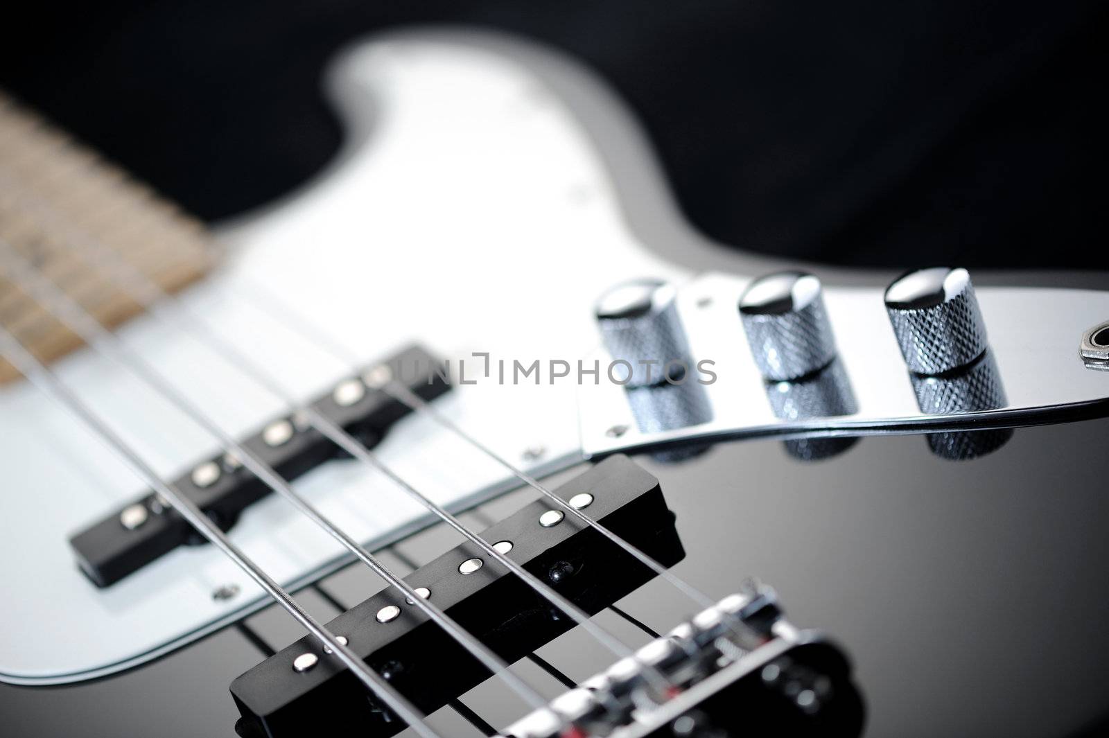 close up of a black electric bass glossy on dark background by stokkete