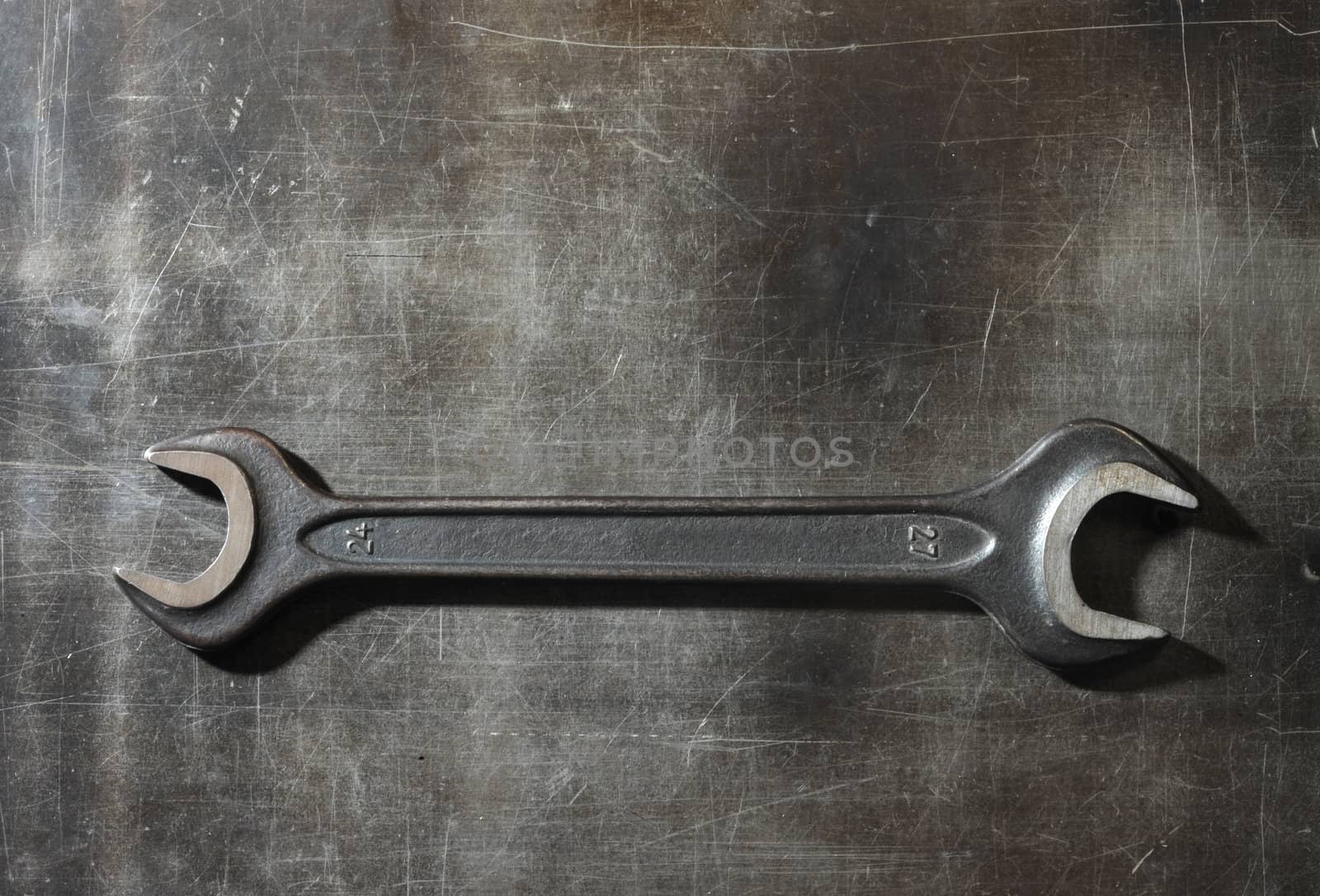 wrench on metal background by stokkete