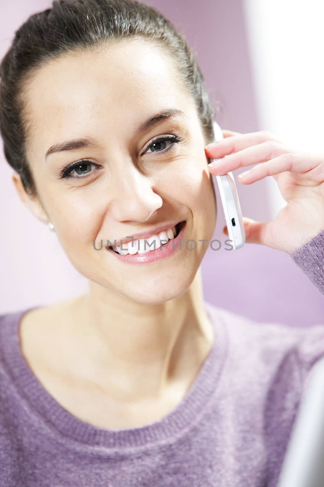 portrait of young smiling woman on phone by stokkete